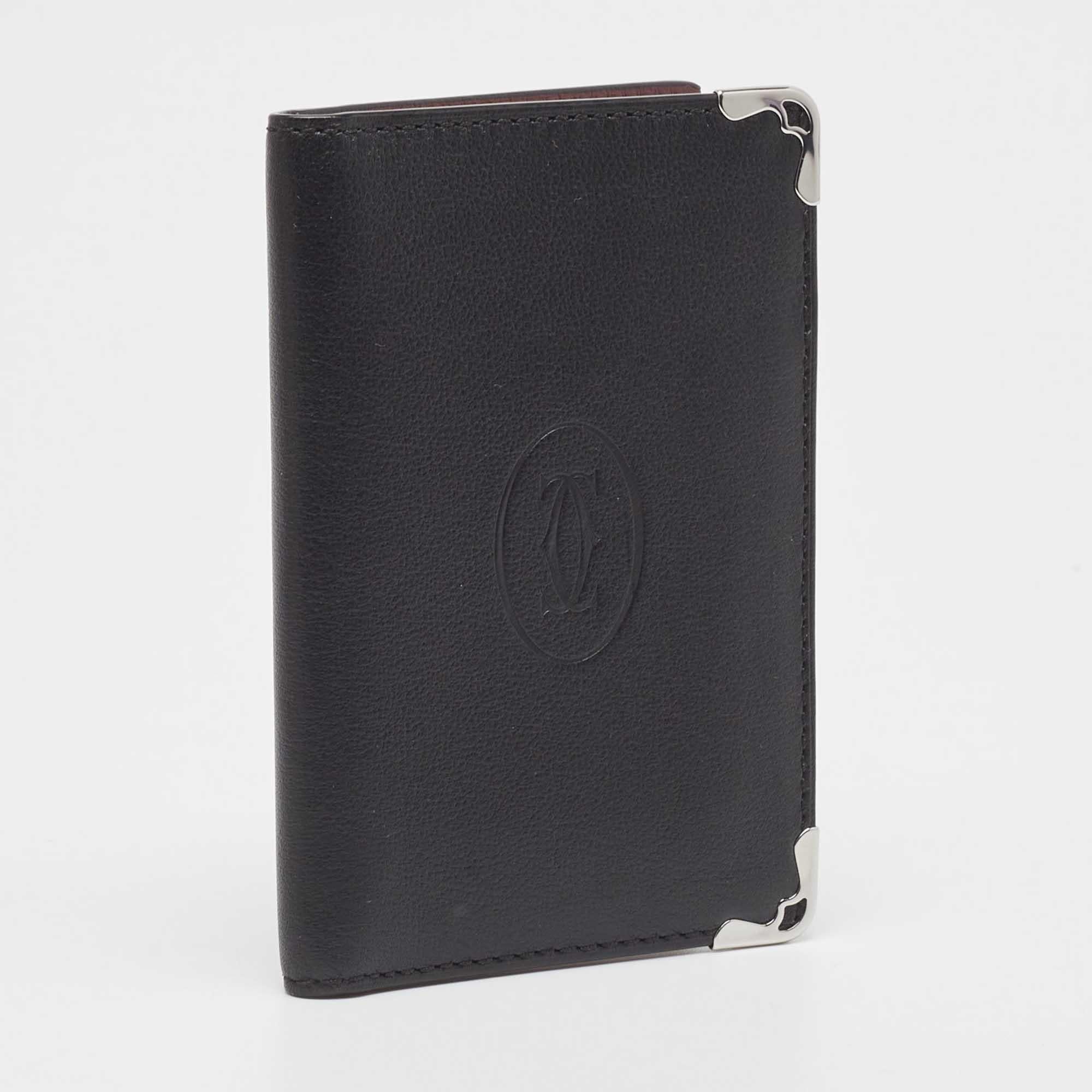 The Cartier card holder combines elegance and functionality in a sleek design. Crafted from leather, it features a black shade and silver-tone metal accents.

