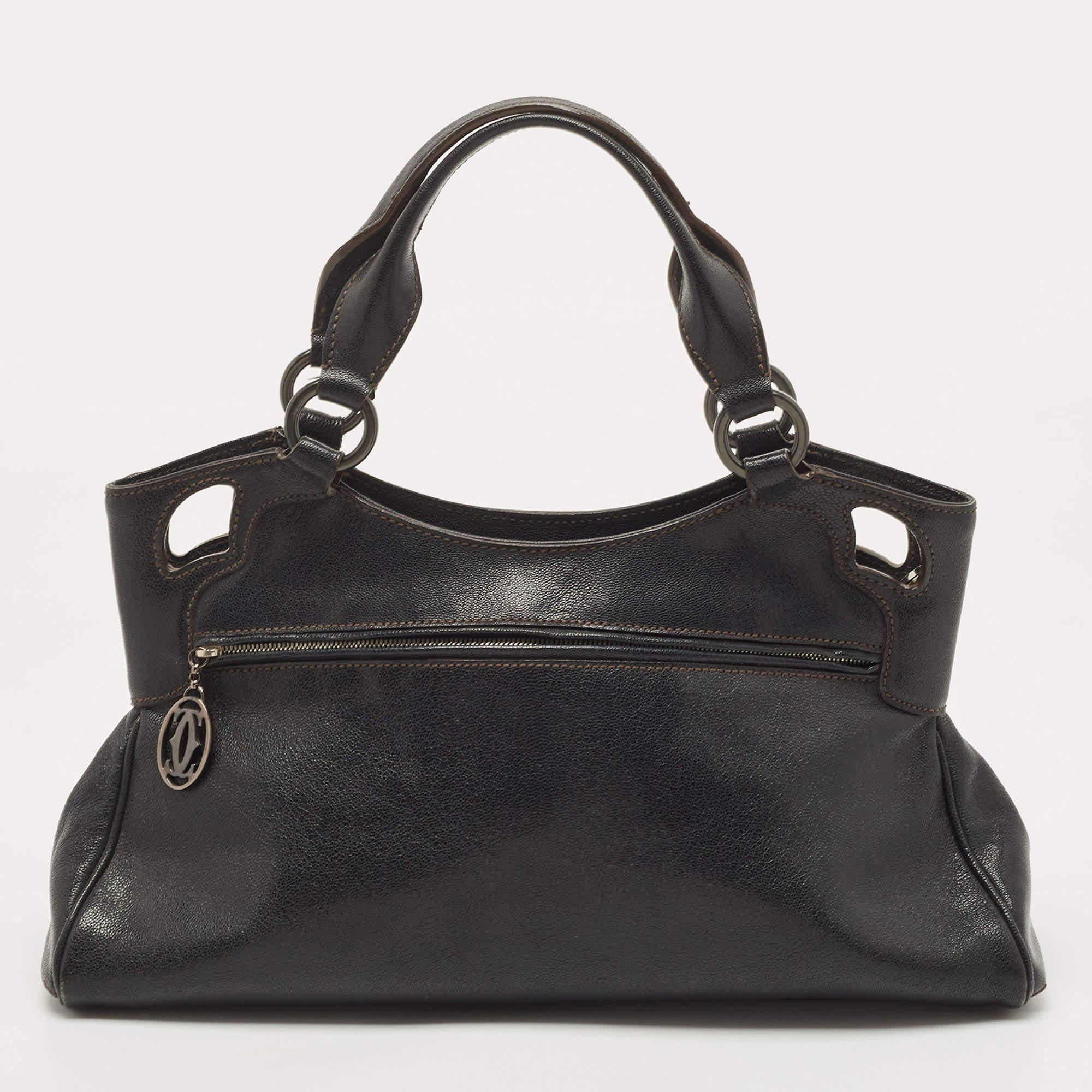 This Cartier beauty arrives in a gorgeous shape and design. It has a leather body with the logo detailing on the exterior and is held by two handles. The zipper secures the nylon interior and overall, the bag looks ready to lift your classic style.

