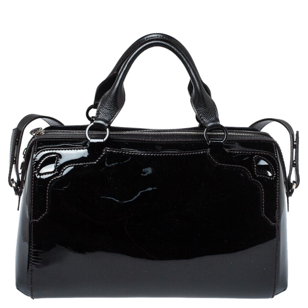 This Cartier beauty arrives in a gorgeous shape and design. It has a patent leather body rendered in a bowler silhouette with a logo charm on the front and is held by two handles. The zipper secures the canvas interior and overall, the bag looks