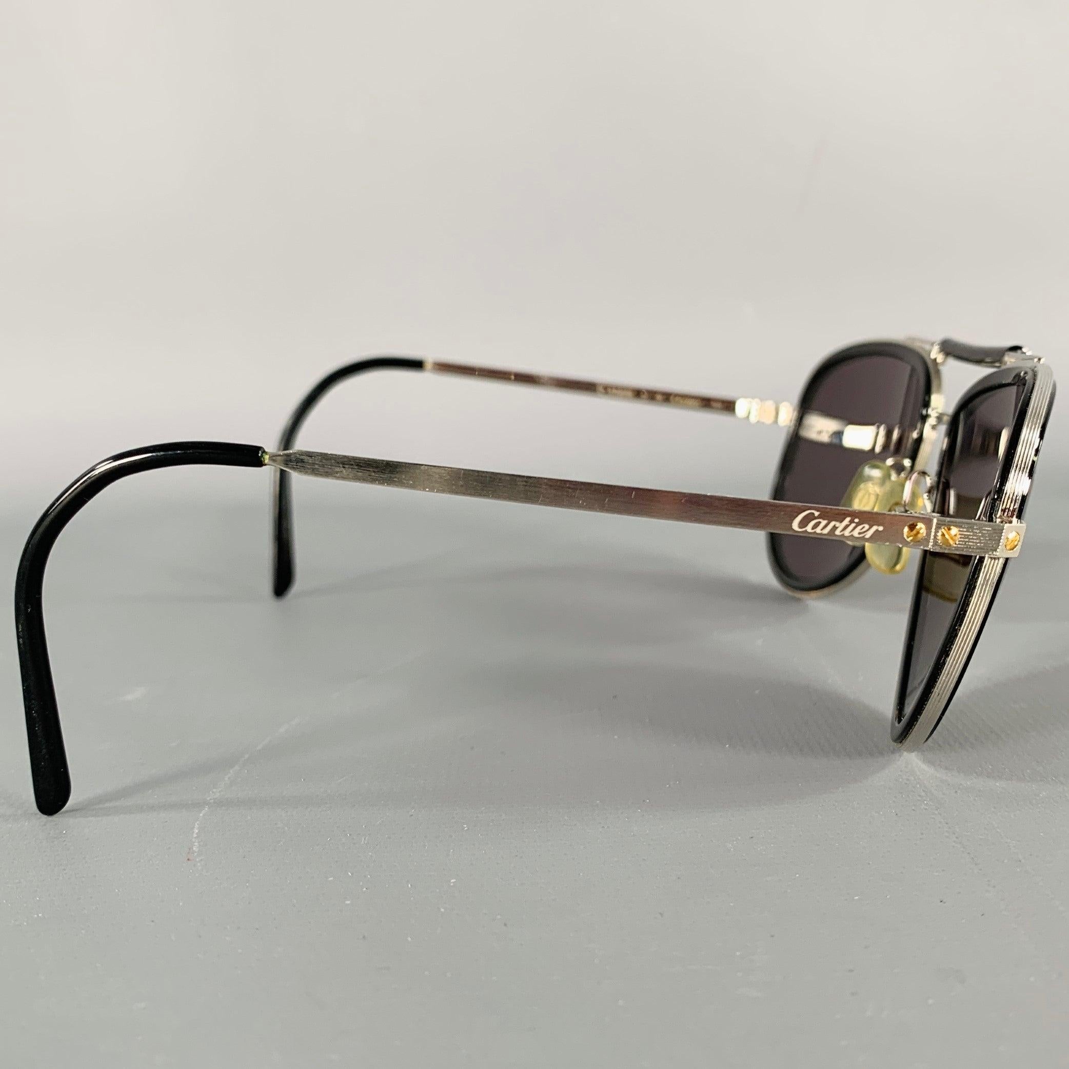 Occhiali da sole Cartier
in acetato nero e metallo argentato con uno stile da aviatore. Viene fornito con una custodia. Made in France.Eccellente condizione di usato. 

Contrassegnato:   B 15808 E 

Misure: 
  Larghezza della cornice: 14,5