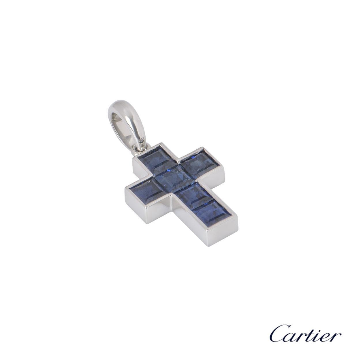 A stunning platinum sapphire pendant by Cartier. The pendant is designed as cross set with 6 square cut sapphires with an approximate weight of 0.90ct. The pendant has a height of 2.00cm with a width of 1.00cm featuring a loop bail and an gross