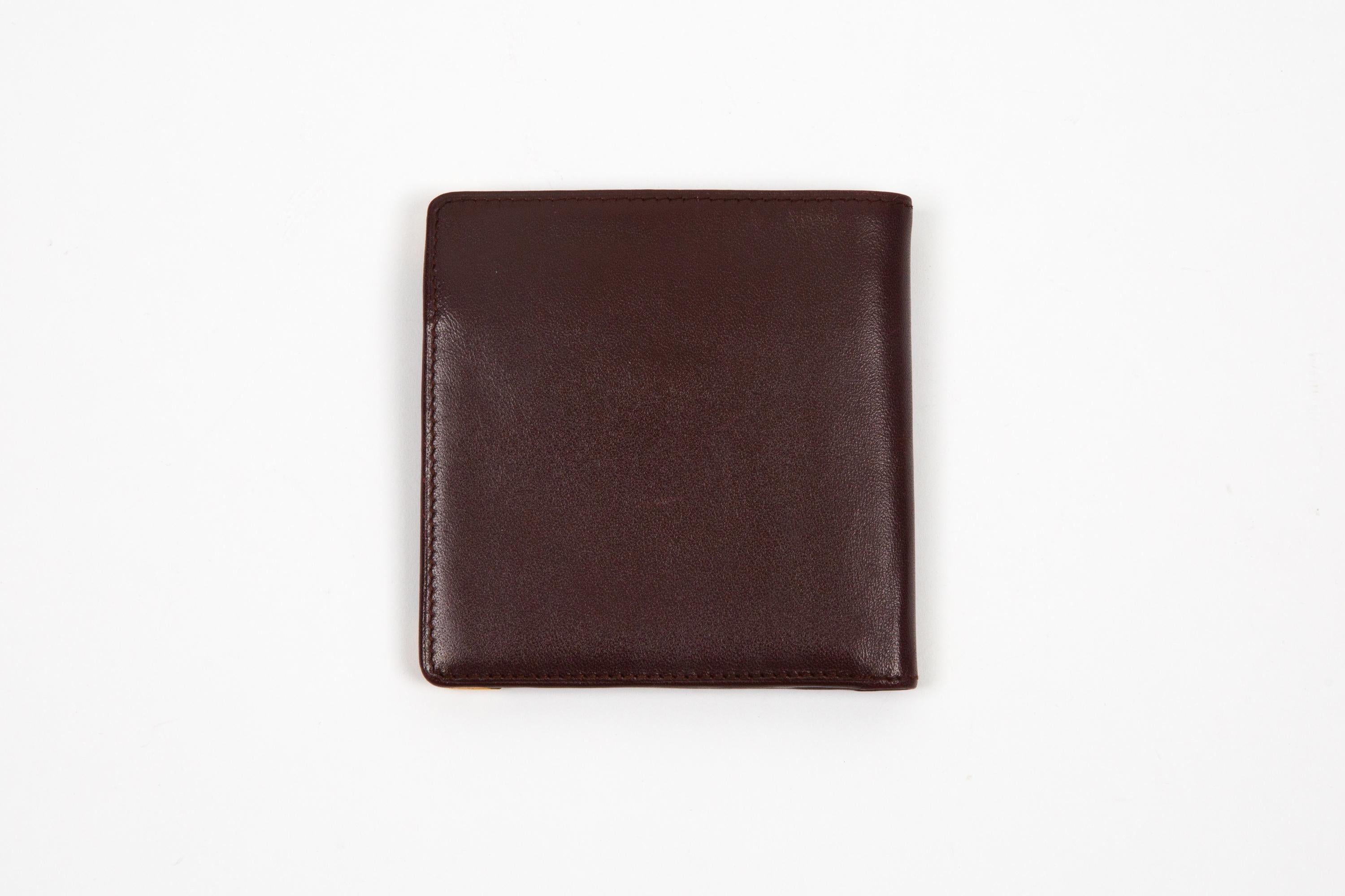 Cartier Bordeaux leather Small square wallet featuring a square shape, gold-plated corners, inside compartments for cards and for money, an inside gold-tone stamp. delivered in original box.
Circa: 1990s
In good vintage condition. Made in