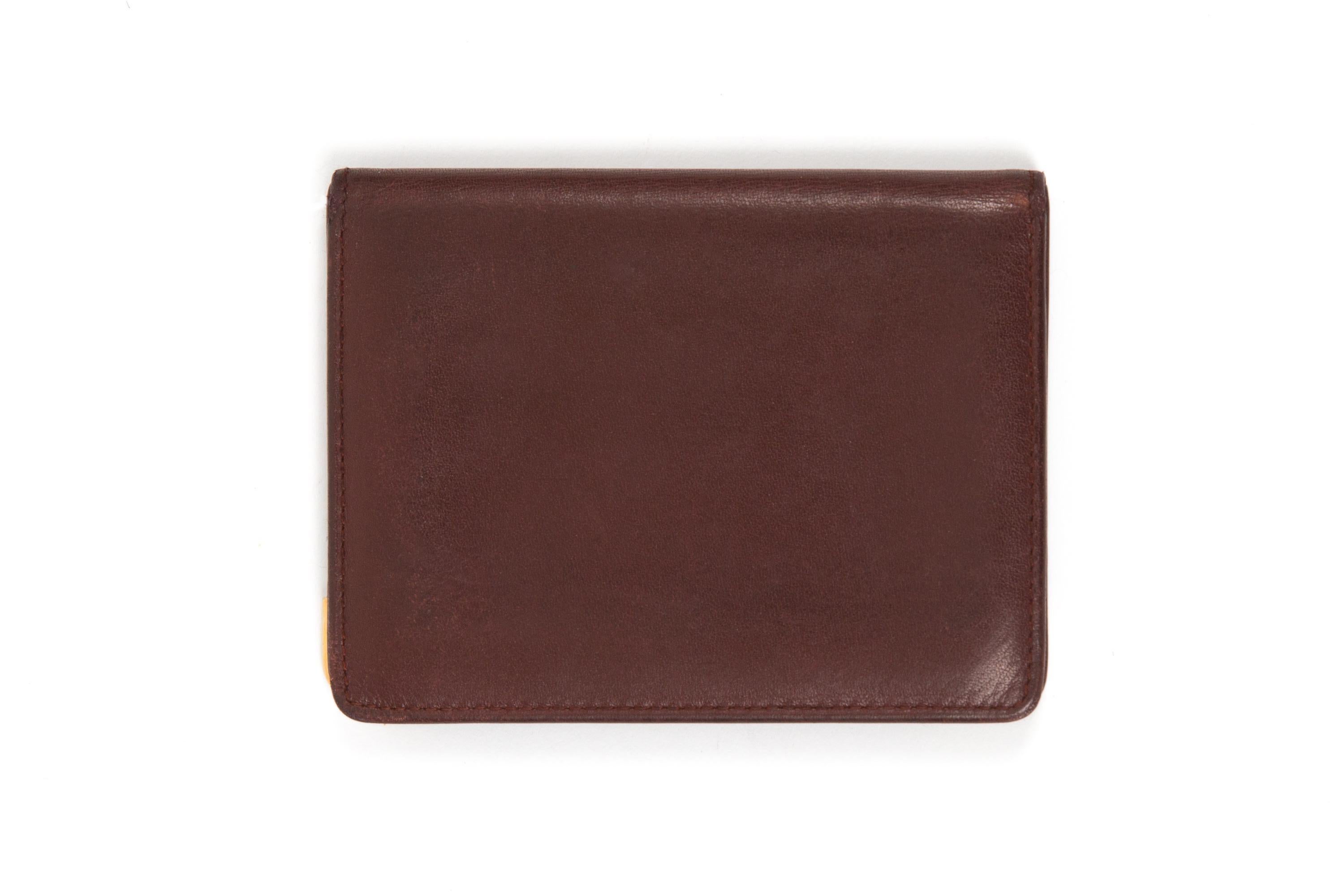 Cartier Bordeaux leather wallet featuring gold-plated corners, inside three credit card pockets and two plastic compartments and a golden hot-stamped Cartier signature. 
Circa: 1990s
In good vintage condition. Made in France.
4.3in. (11cm)X 3.1in.