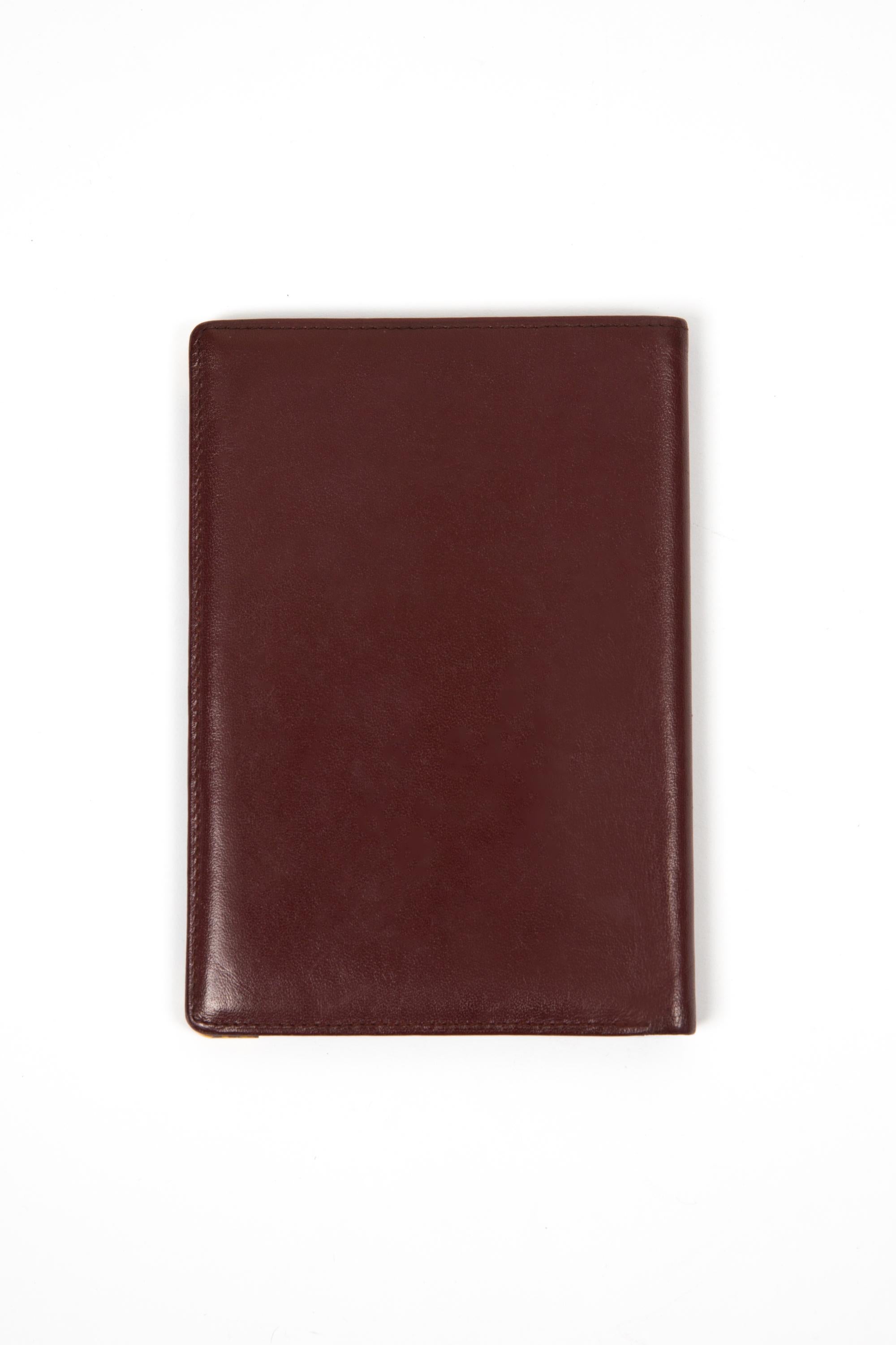 Cartier Bordeaux textured long leather wallet featuring  inside six credit card pockets, two flat pockets and a plastic compartment and a golden hot-stamped Cartier signature. 
Circa: 1980s
In good vintage condition. Made in France.
5.9in. (15cm) X