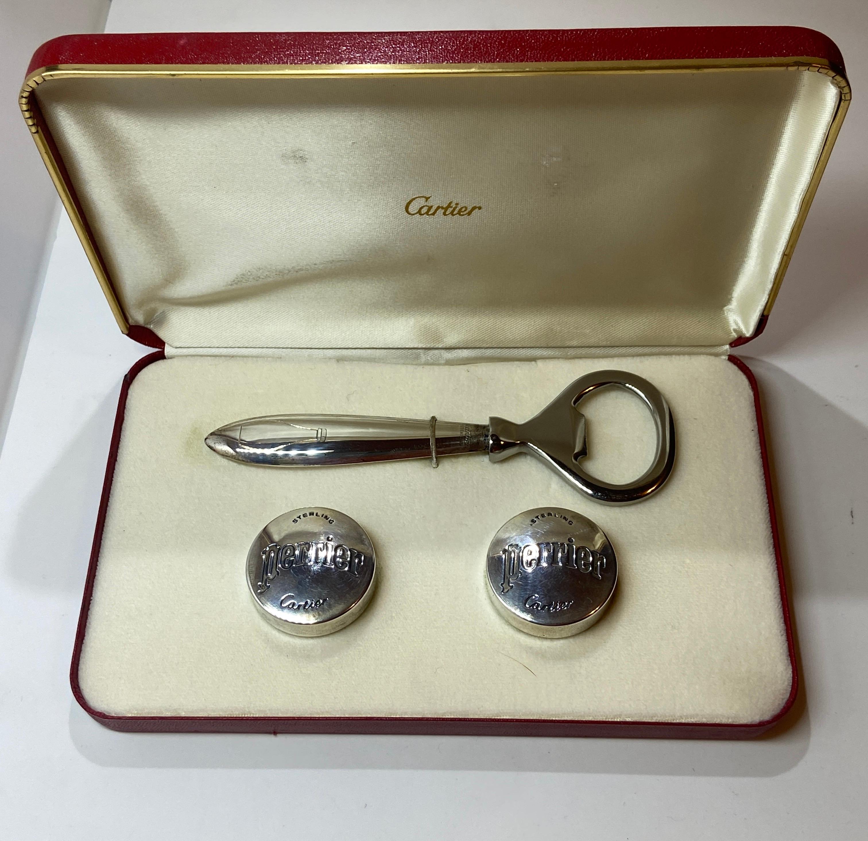 Der wunderbar skurrile Flaschenöffner aus Sterlingsilber von Cartier und das Set mit Perrier-Flaschenverschlüssen wird in einer originalen Signaturbox geliefert. Die Flaschendeckel messen jeweils 1 2/8 Zoll im Umfang. Der Flaschenöffner misst 5 Zoll