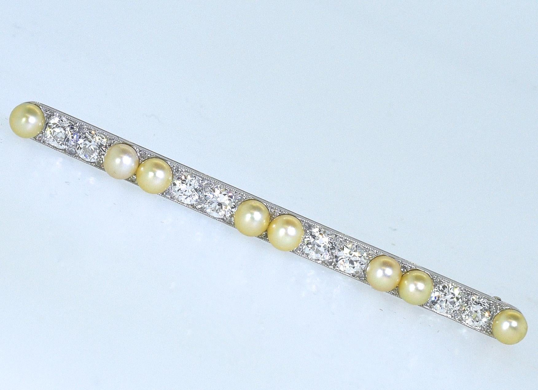 Cartier pin with 8 natural oriental pearls surrounded by 28  rose cut diamonds and centering 8 early mine cut diamonds amounting to 2.00 cts.  This platinum piece is signed on the verso Cartier.  This piece is three inches long, well made, and in
