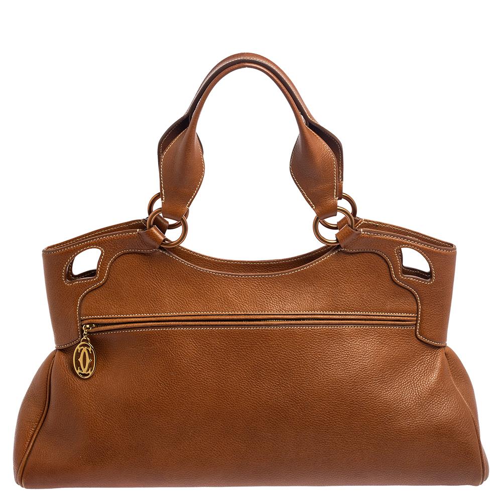 This Cartier beauty features a gorgeous shape and design. It has a leather body with logo detailing on the exterior and is held by two handles. The zipper secures the fabric interior and overall, the bag promises to lift uphold and elevate your