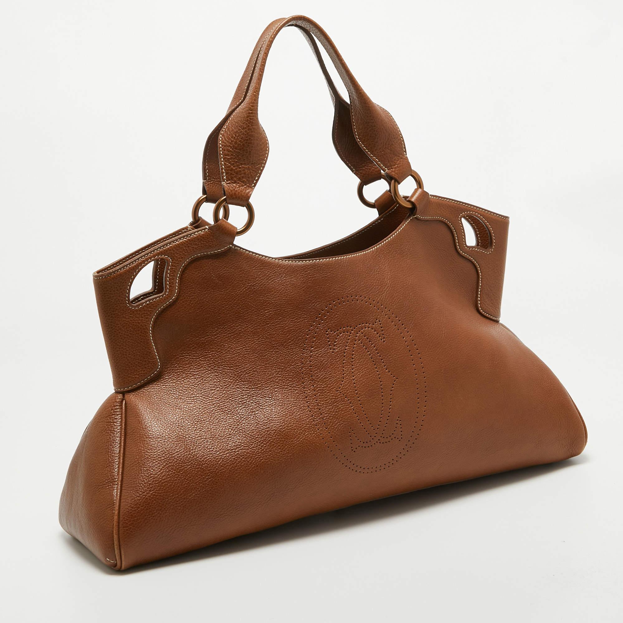 This Cartier beauty arrives in a gorgeous shape and design. It has a leather construction with logo detailing and two handles on top. The zipper secures the fabric interior and overall, the bag looks ready to lift your classic style.

Includes: