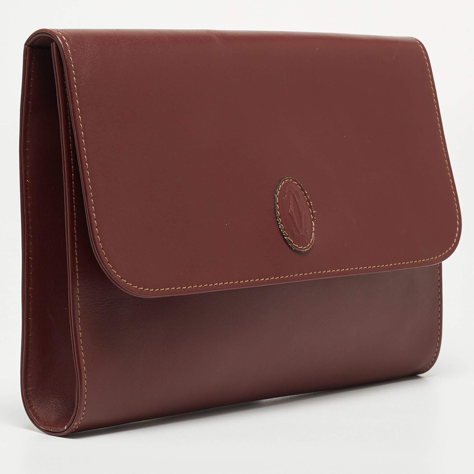 With a functional design, this Cartier clutch is a reliable accessory. Crafted from leather, it displays brand detailing on the front flap, and its lined interior will keep your valuables neatly.

