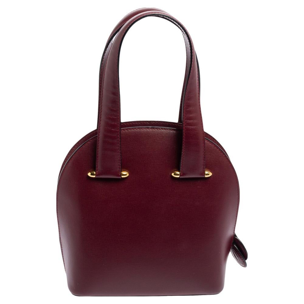 Designed to deliver style and functionality, this tote bag by Cartier has been crafted from leather. It features dual handles, a fabric interior, and gold-tone hardware.

Includes: Authenticity Card
