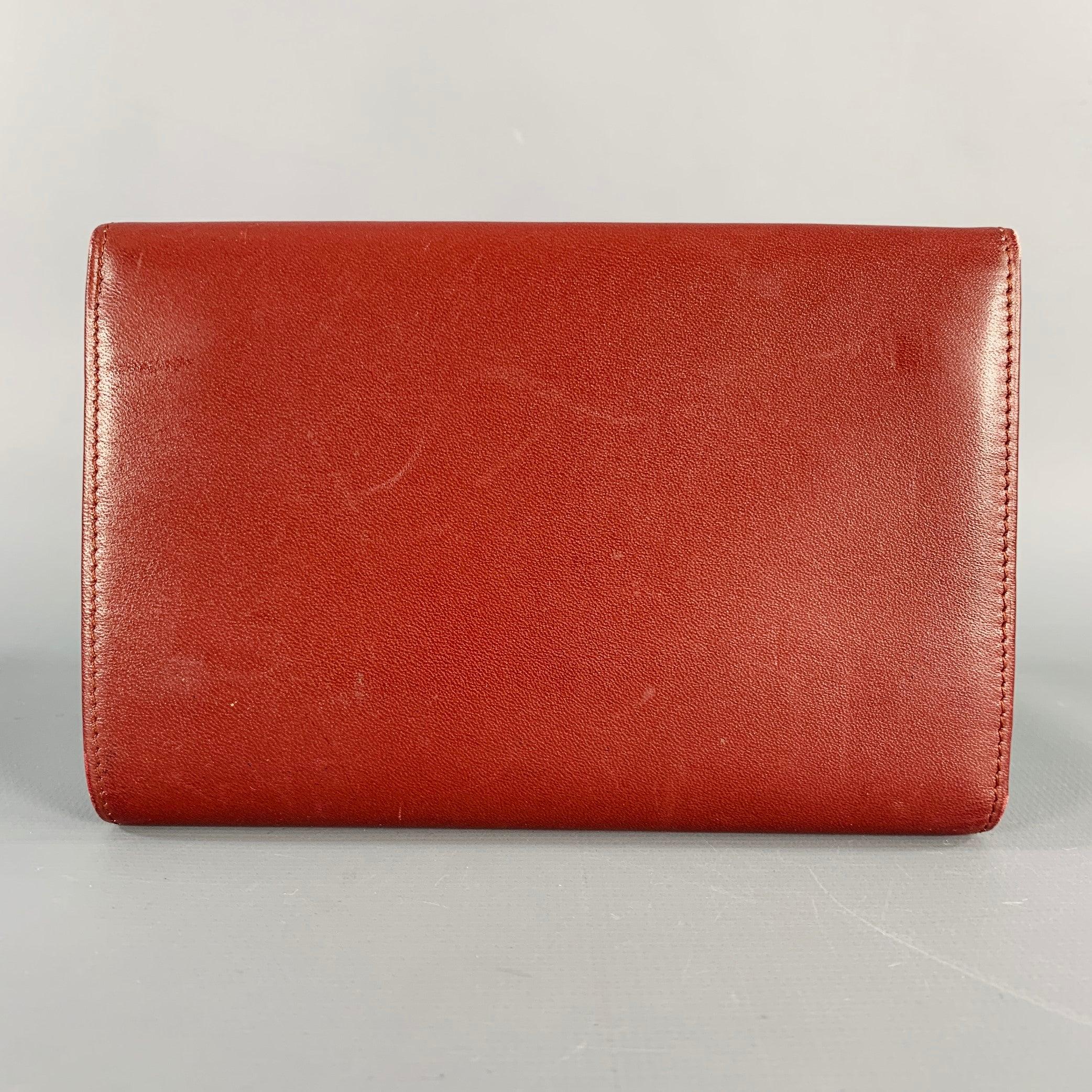 CARTIER PARIS wallet
in a burgundy leather with gold tone metal details featuring kiss lock coin purse, and snap closure. Very Good Pre-Owned Condition. Minor signs of wear. 

Marked:   284141789 

Measurements: 
  5.5 x 3.5 inches 
  
  
 
Sui