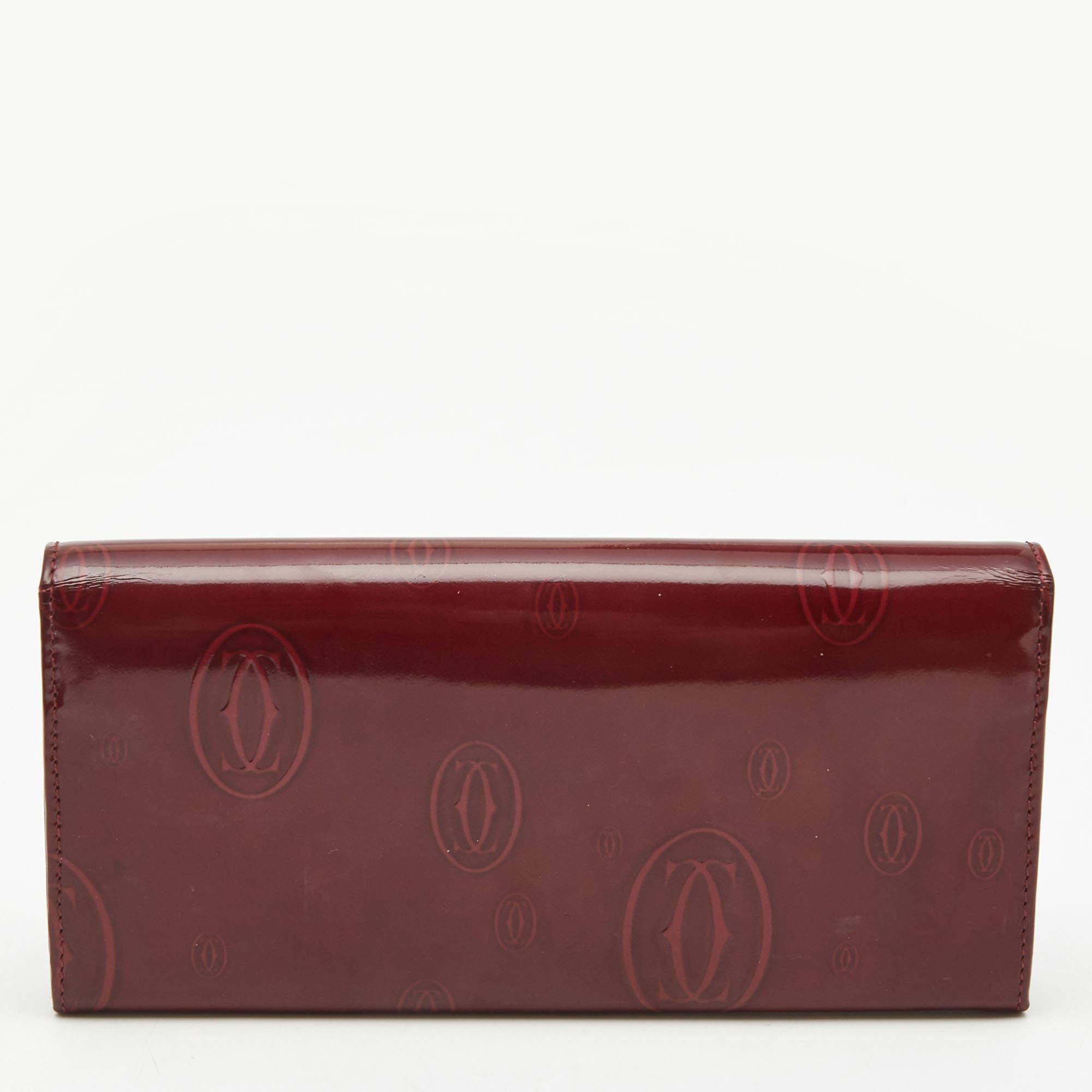 This Happy Birthday continental wallet from Cartier is designed to offer functionality and style. Crafted from patent leather, this wallet showcases brand detailing on the exterior. It is charming with silver-tone accents, and its compartmentalized