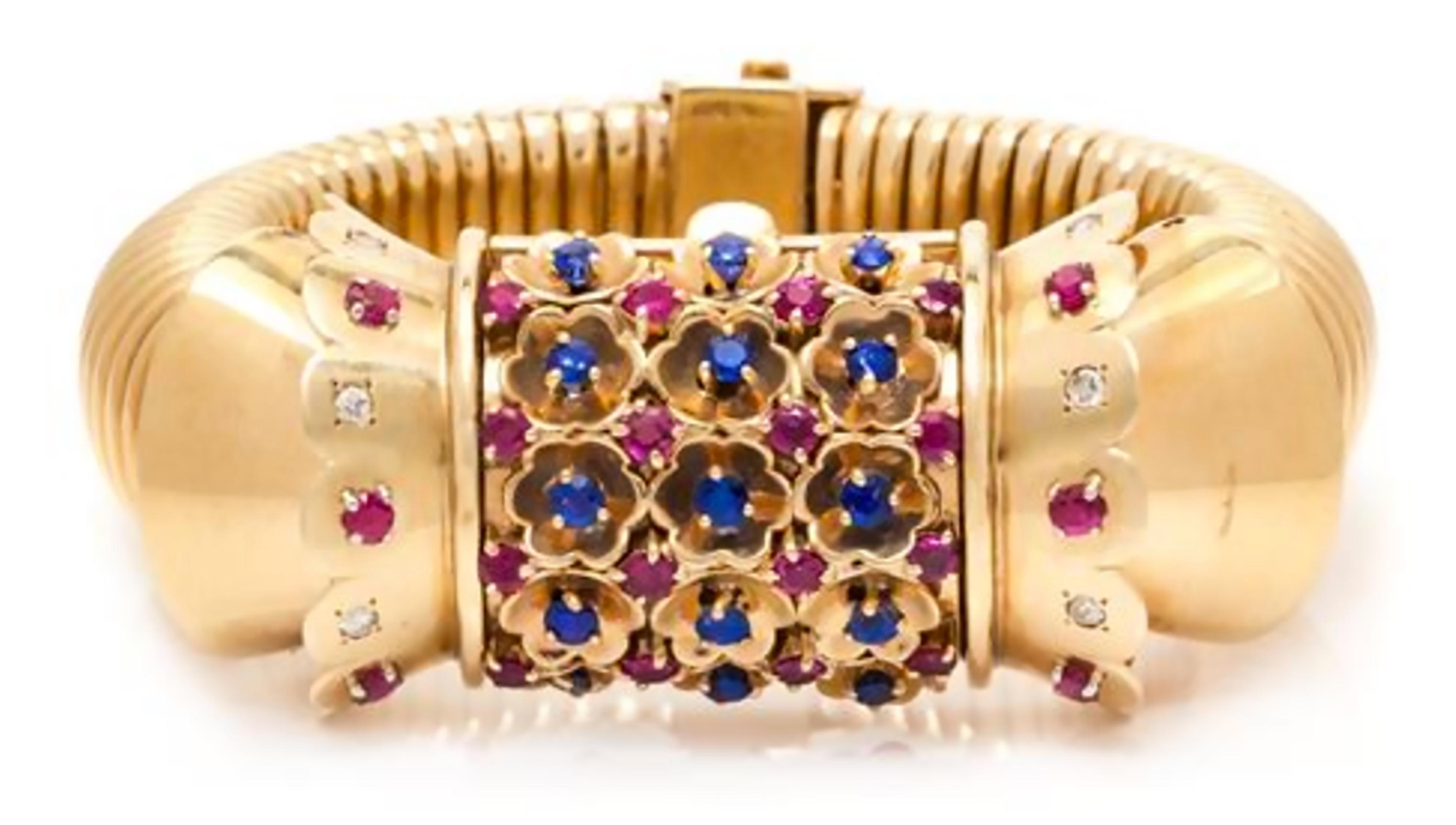 A Retro Rose Gold, Ruby, Sapphire and Diamond Surprise Watch- Bracelet, John Rubel for Cartier, circa 1950s. The hinged dial cover containing 15 round mixed cut sapphires measuring approximately 2.80 mm in diameter, 22 round mixed cut rubies