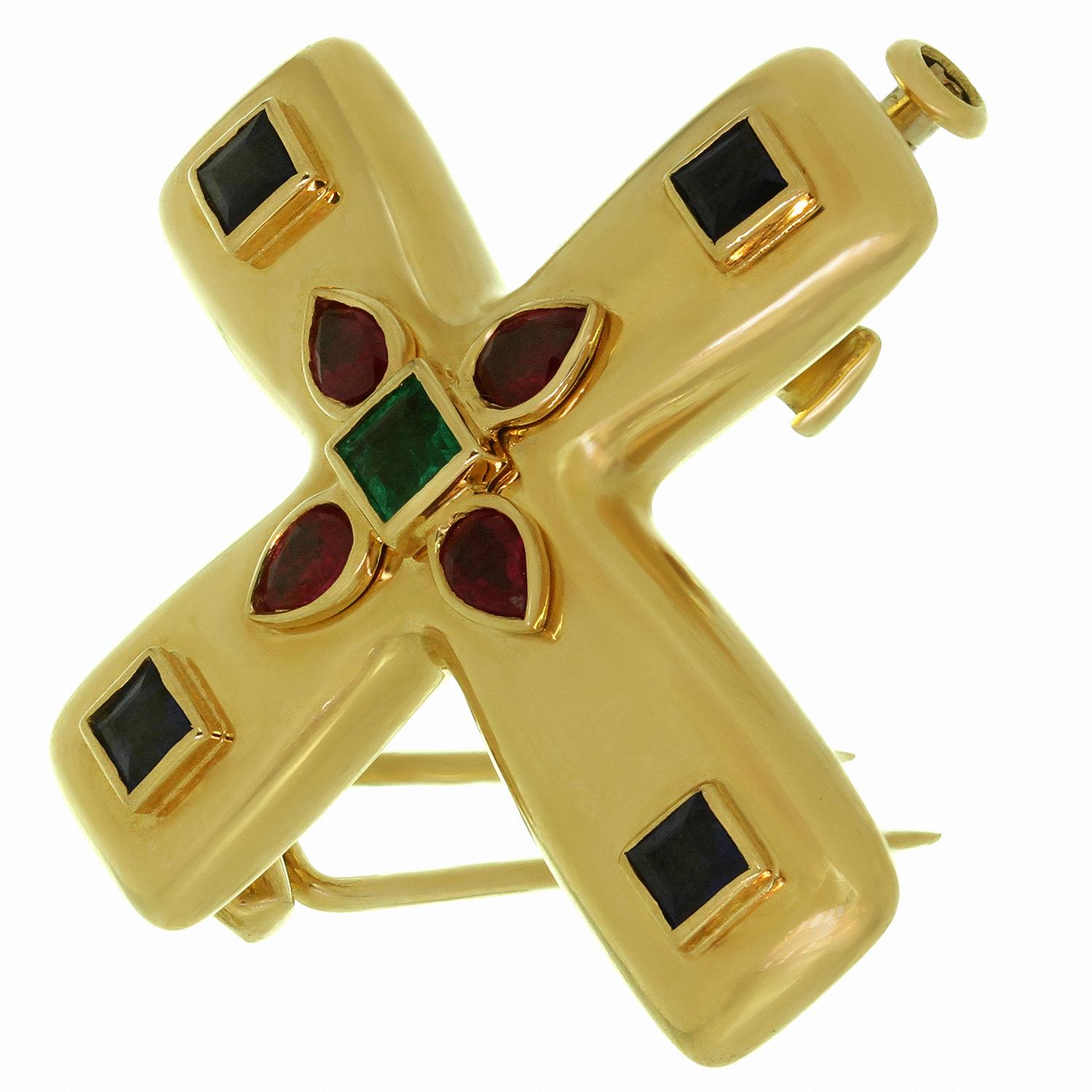 This iconic Cartier medium cross pendant brooch is crafted in 18k yellow gold and set with faceted rubies, sapphires, and emerald.  The Byzantine motif was designed by Louis Cartier during his trip to Russia in the early part of the 20th century,