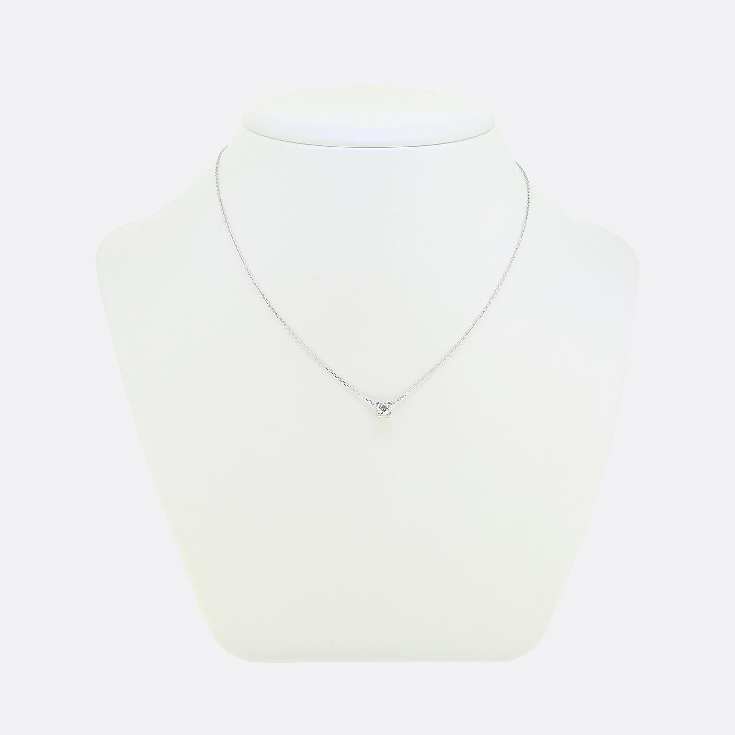 Ecco una raffinata collana in oro bianco 18 carati della rinomata casa di gioielli di lusso Cartier. Il pezzo presenta un singolo diamante bianco brillante dal taglio rotondo, elegantemente incastonato in un design minimalista con l'iconico motivo