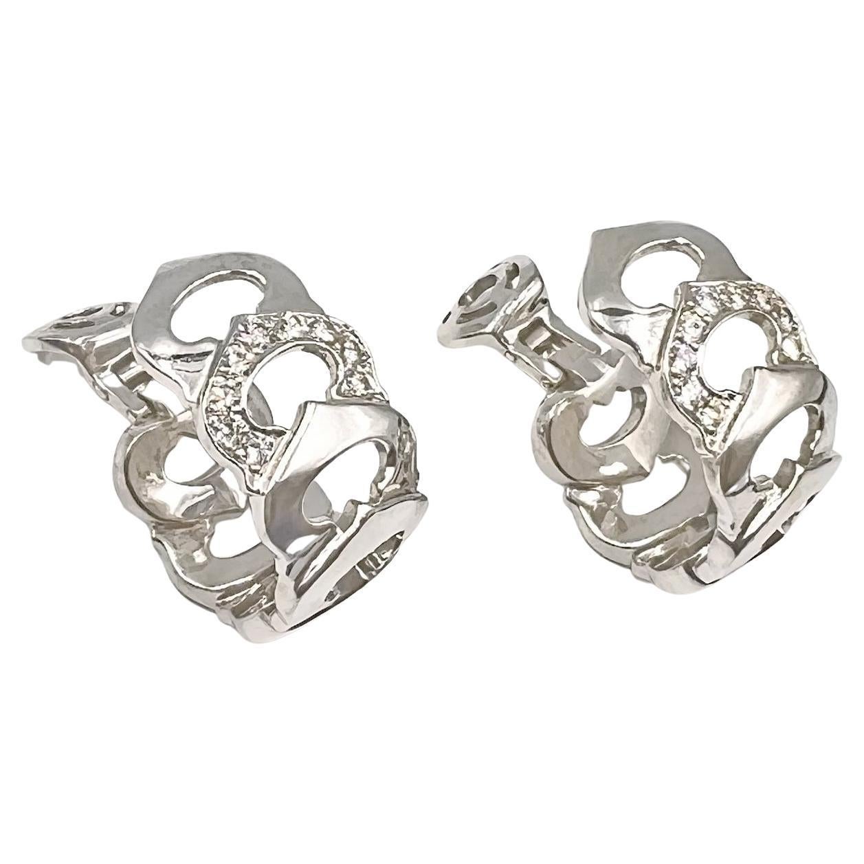 'C' de Cartier 18k white gold and diamond earrings.  Interlocking 'C' motif links in polished 18k white gold accented by a single link at center set with round brilliant-cut diamonds.  Diamonds weighing 1.26 total carats (E-F color, VVS-VS clarity).