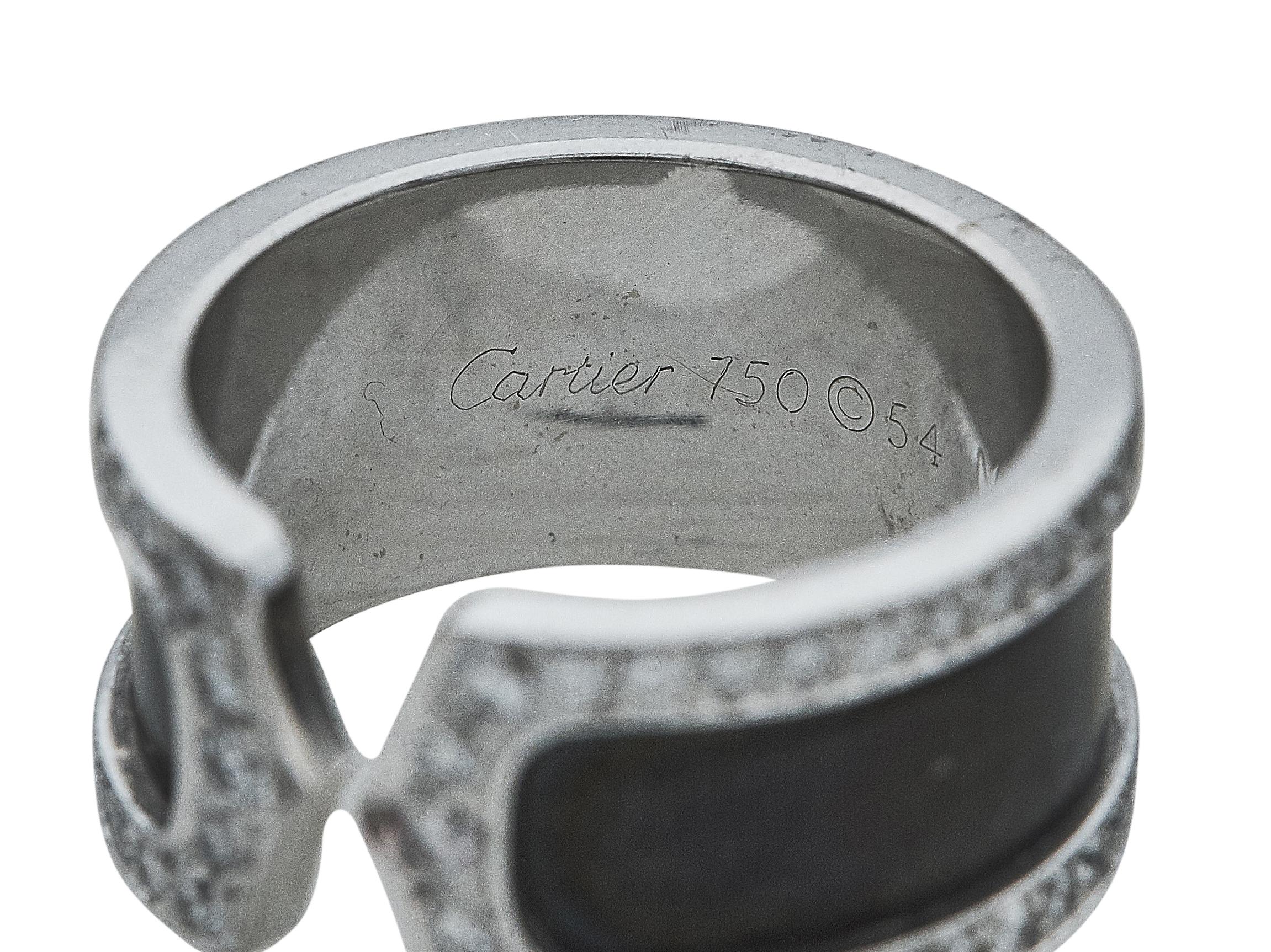 Un anello:
Un anello A.I.C. di Cartier. Il design è quello di una fascia in smalto nero e oro bianco a diciotto carati, che termina con due C di diamanti tondi taglio brillante contrapposte.

L'anello è in condizioni eccellenti, con solo qualche