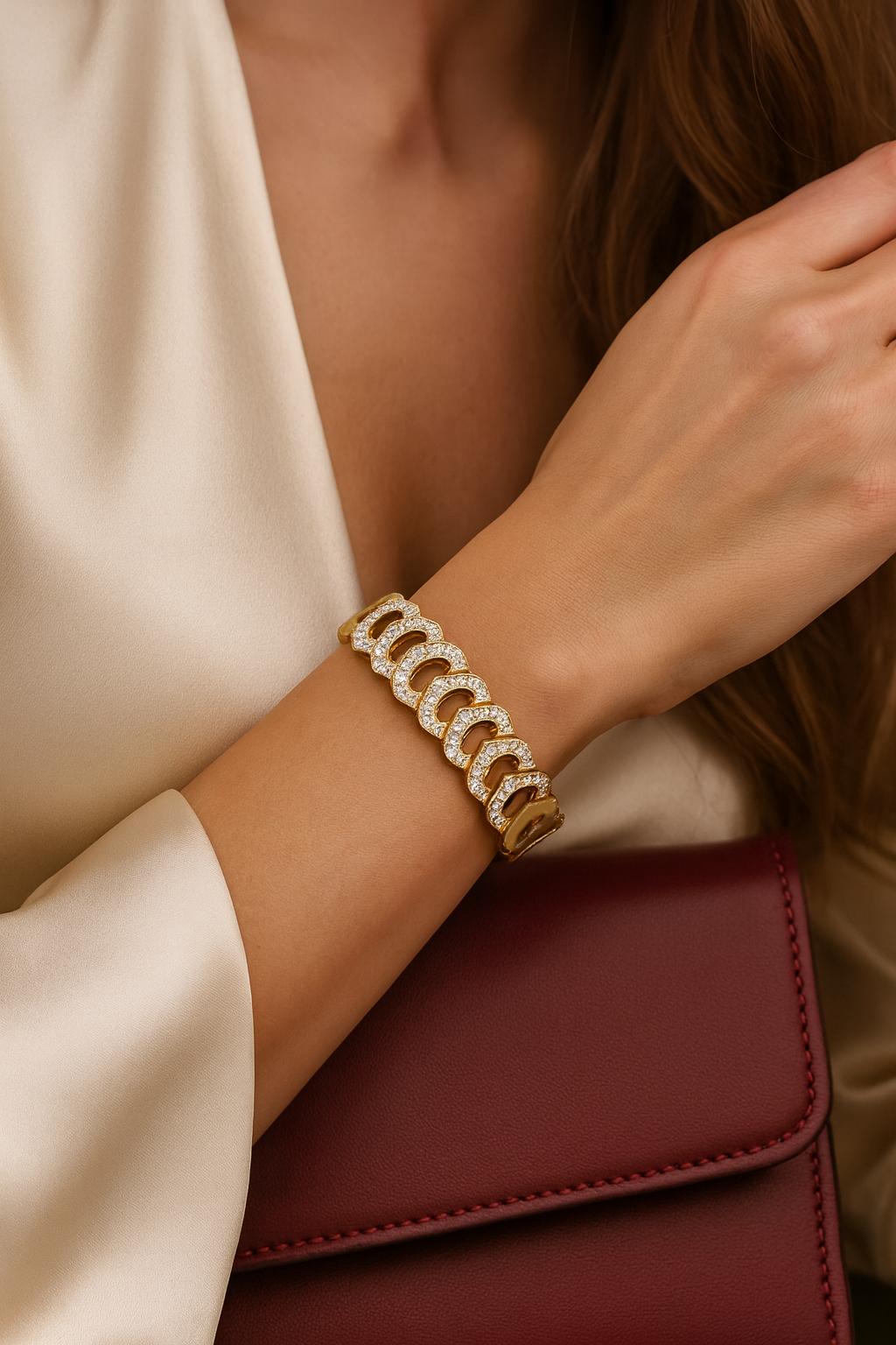 An icon of timeless elegance, this Cartier “C de Cartier” link bracelet is crafted in luminous 18k yellow gold, creating a sophisticated contrast of warm tones. The design is enriched with brilliant round diamonds of exceptional quality, adding a