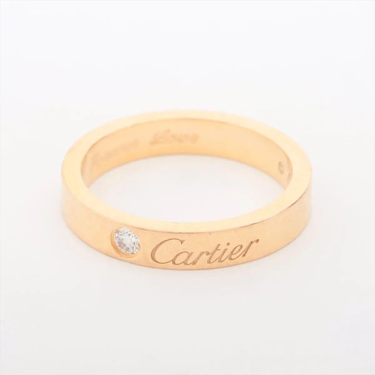The Cartier C de Cartier Wedding Ring in yellow gold is a refined and elegant symbol of enduring love. Crafted from radiant 18k yellow gold, the band features a single, brilliant-cut diamond set into its polished surface, offering a discreet yet