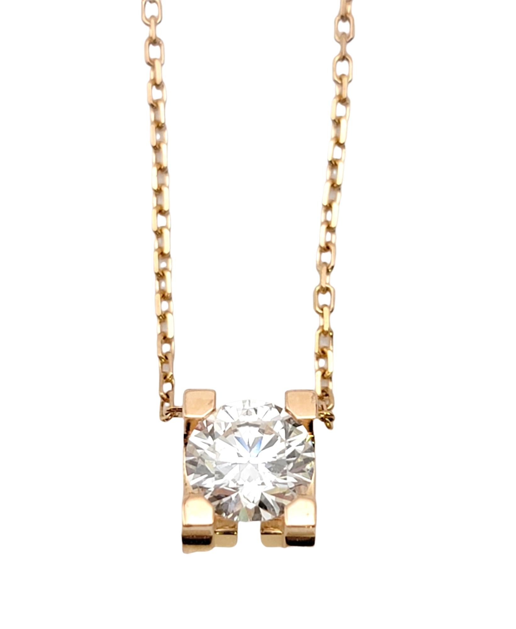 Ce superbe collier pendentif solitaire en diamants étincelants de Cartier est la quintessence de l'élégance discrète. Dotée d'une chaîne délicate et d'un diamant rond naturel solitaire serti de 4 griffes à l'extrémité de l'initiale 