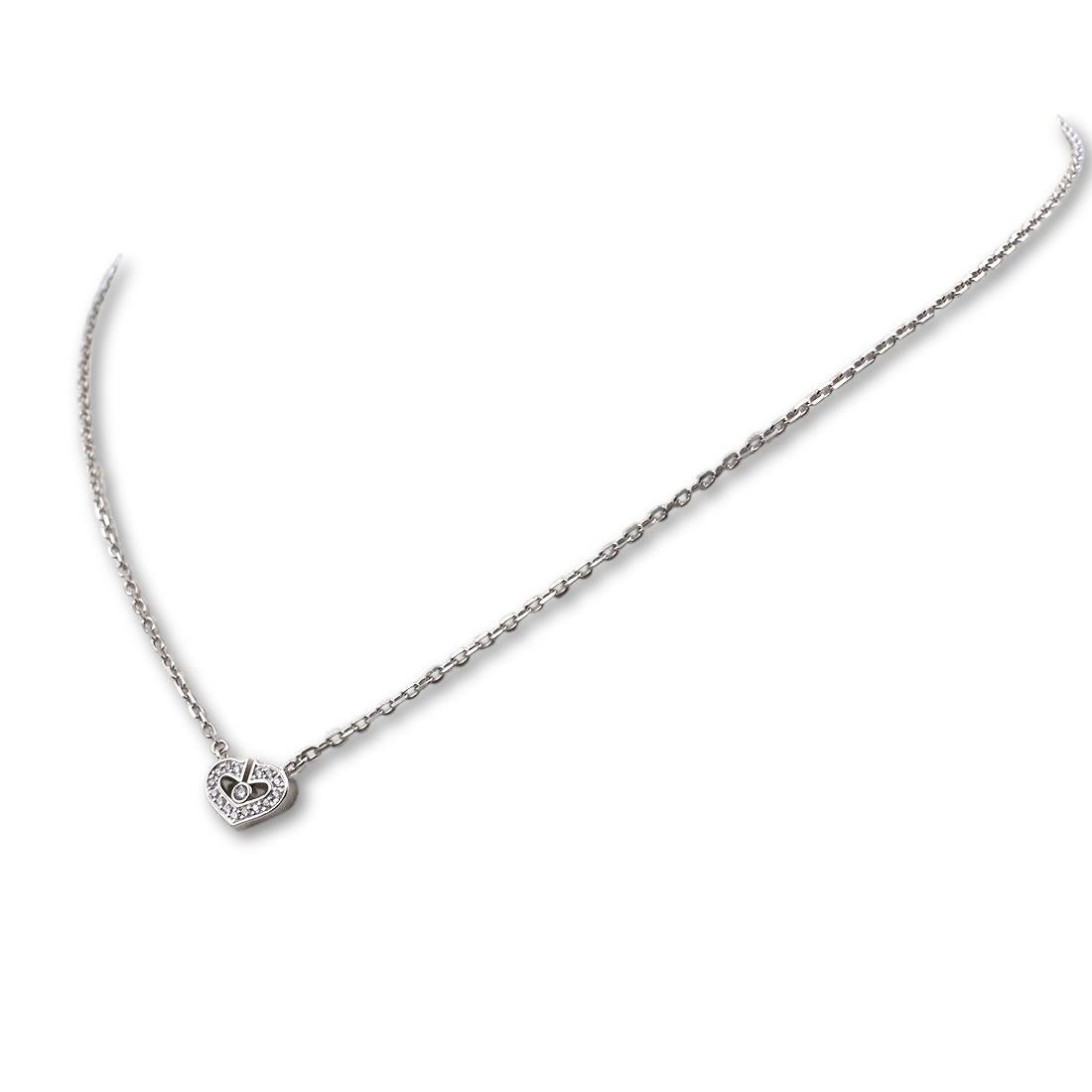 Authentic 'C de Cartier' necklace crafted in 18 karat white gold. The heart-shaped pendant, comprised of two Cartier 'C's, is set with approximately .07 carts of round brilliant diamonds. The pendant measures 10mm x 7.2mm and hangs from a 15.5 inch
