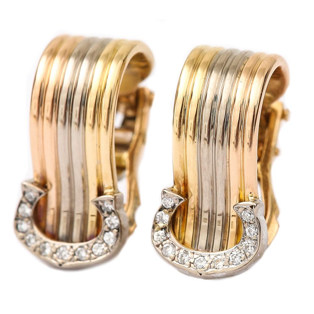A pair of classic Cartier 18 karat tri-colour gold diamond set ‘C’ design earrings. In white, yellow and pink gold, displaying eleven diamonds that are estimated 0.10 carats each earring. Made for pierced ears they have safety catches to ensure the