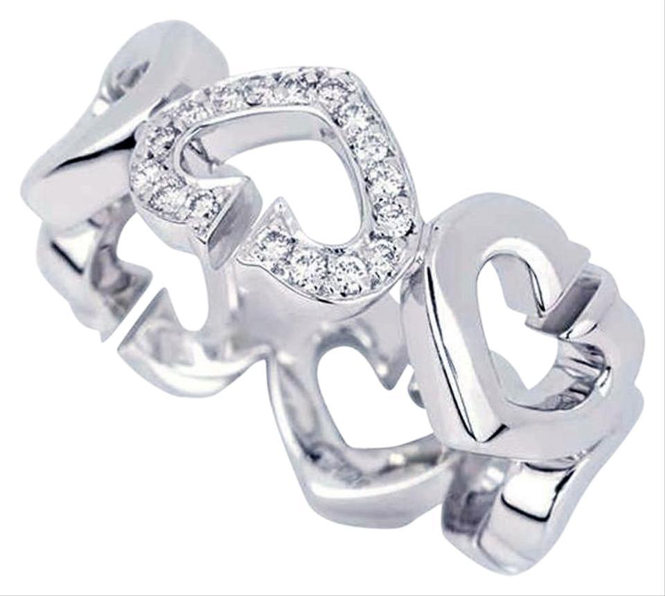C Heart of Cartier ring in 18k white gold. This Cartier band features a heart motif eternity band set with brilliant-cut diamonds weighing 0.10 carats. Cartier size 49 (US size 4) and can not be resized. The ring measures approximately 7.6 mm in