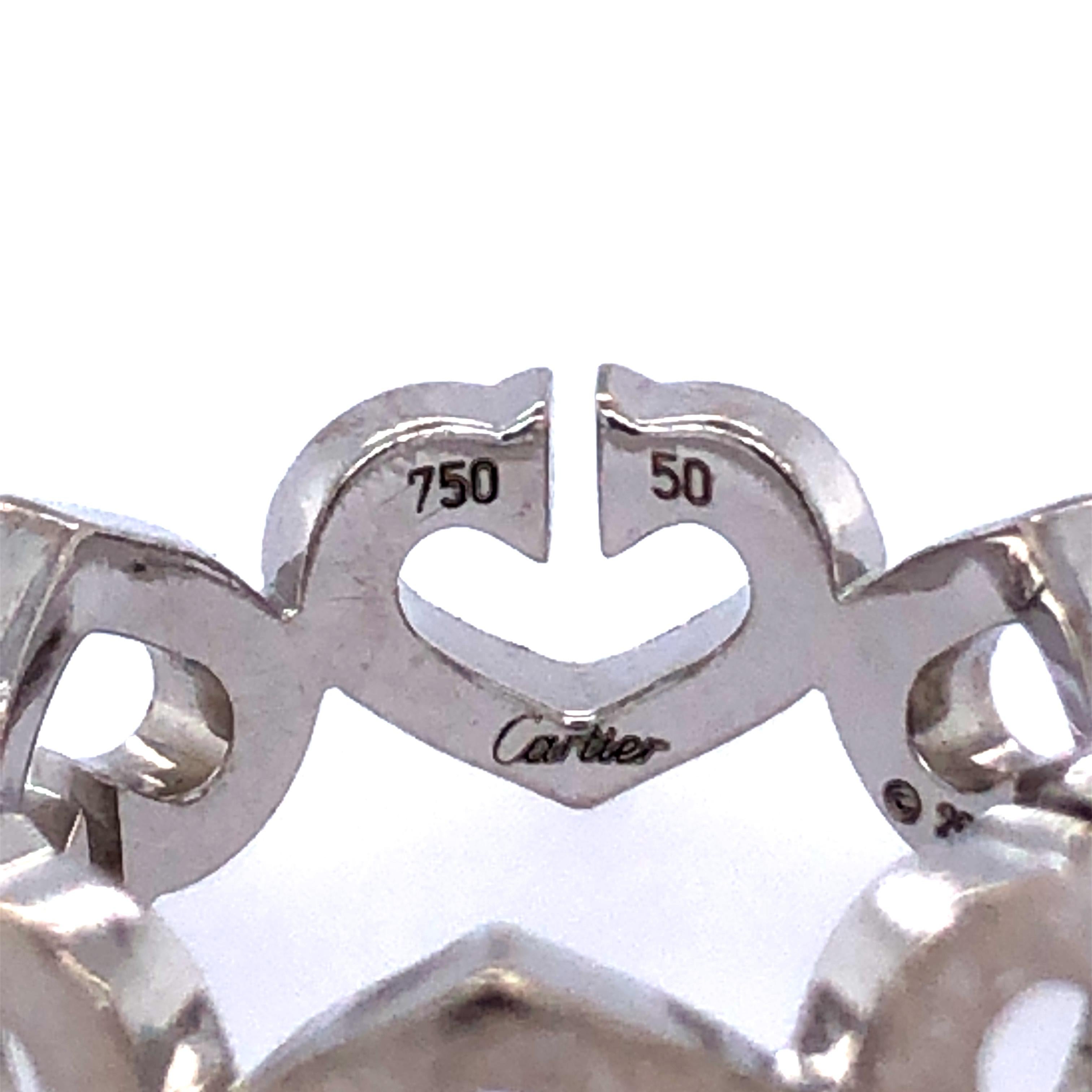 An iconic 18k white gold Cartier ring from the Hearts and Symbols collection. The 6 signature 'double C's' are joined to form small open work heart motifs, set to the centre with a single pave set heart motif. The ring is a US size 5.2 I and has a