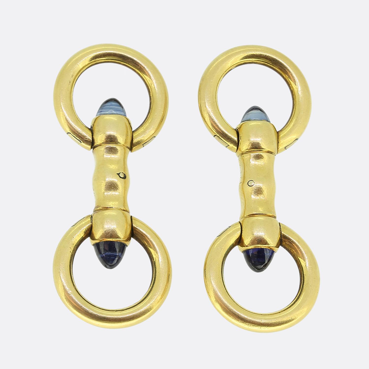 Here we have a smart and sophisticated pair of 18ct yellow gold cufflinks from the world renowned luxury jewellery house of Cartier. Each identical piece features a blue sugarloaf sapphire set at the either end. The design includes circular gold