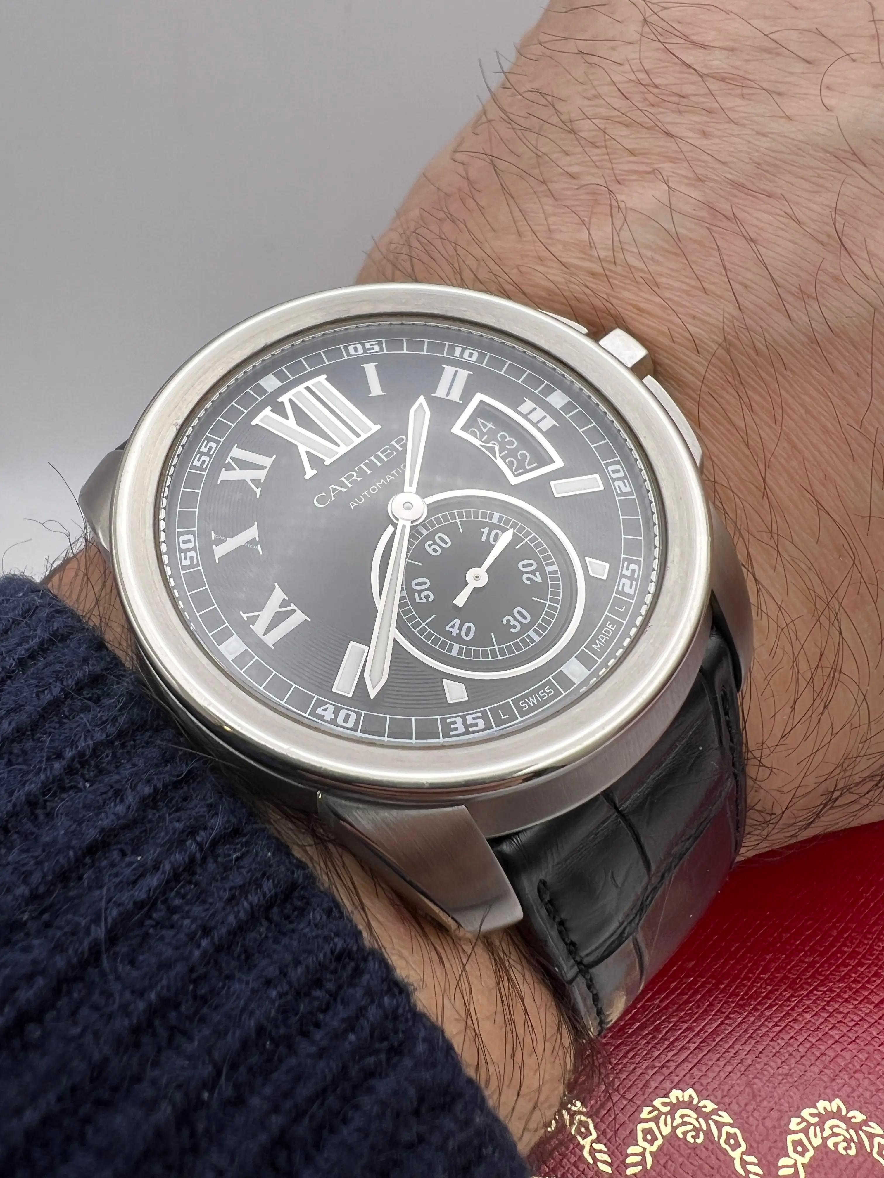 The Cartier Calibre de Cartier (ref. W7100041) is a commanding yet refined 42mm stainless steel timepiece, striking a balance between sporty presence and elegant sophistication. It features a bold black guilloché dial accented by luminous Roman