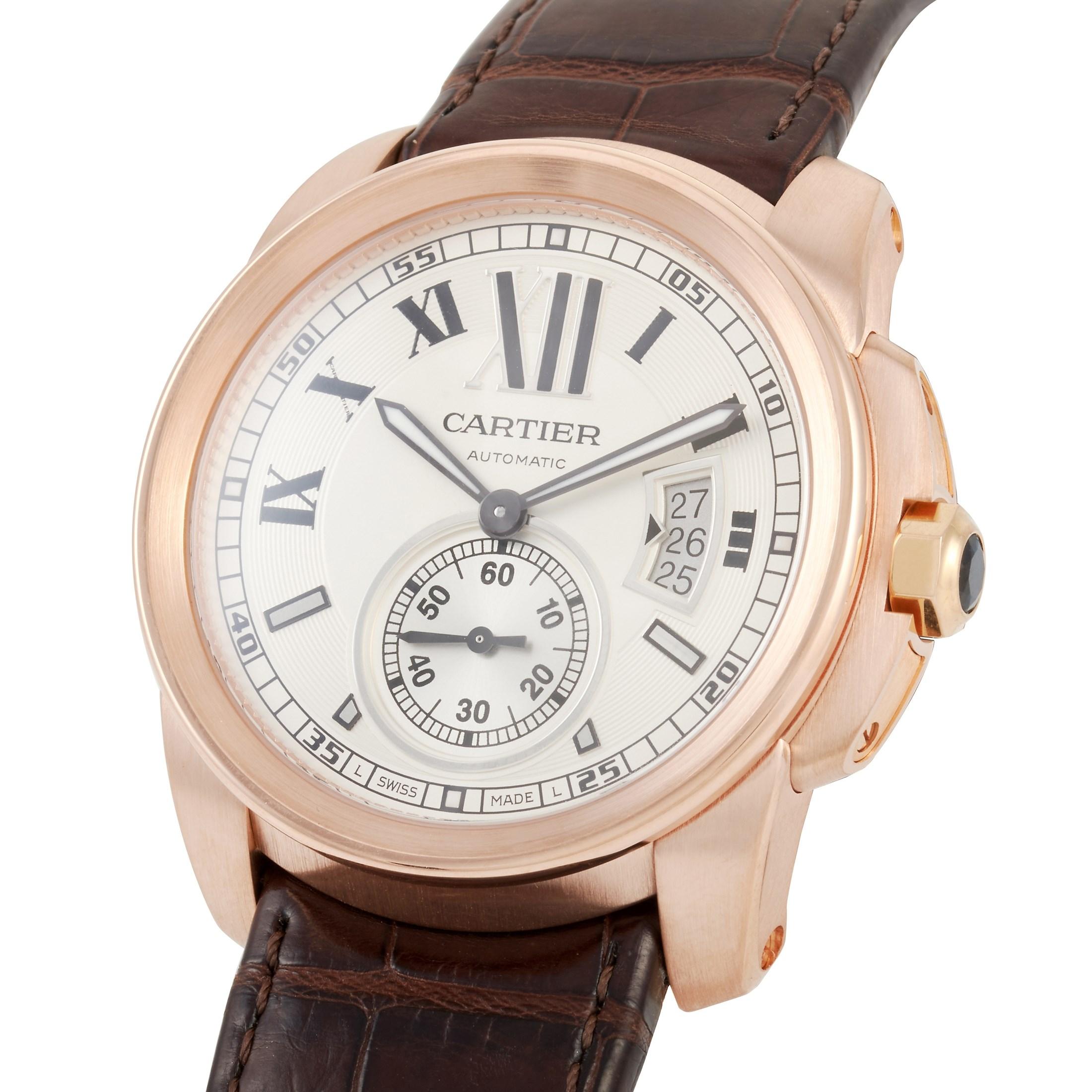 This Calibre De Cartier Automatic 18K Rose Gold Watch, reference number W7100009, features an 18K Rose Gold case measuring 42 mm in diameter. It is presented on an attractive deep brown alligator leather bracelet with a tang clasp. The transparent