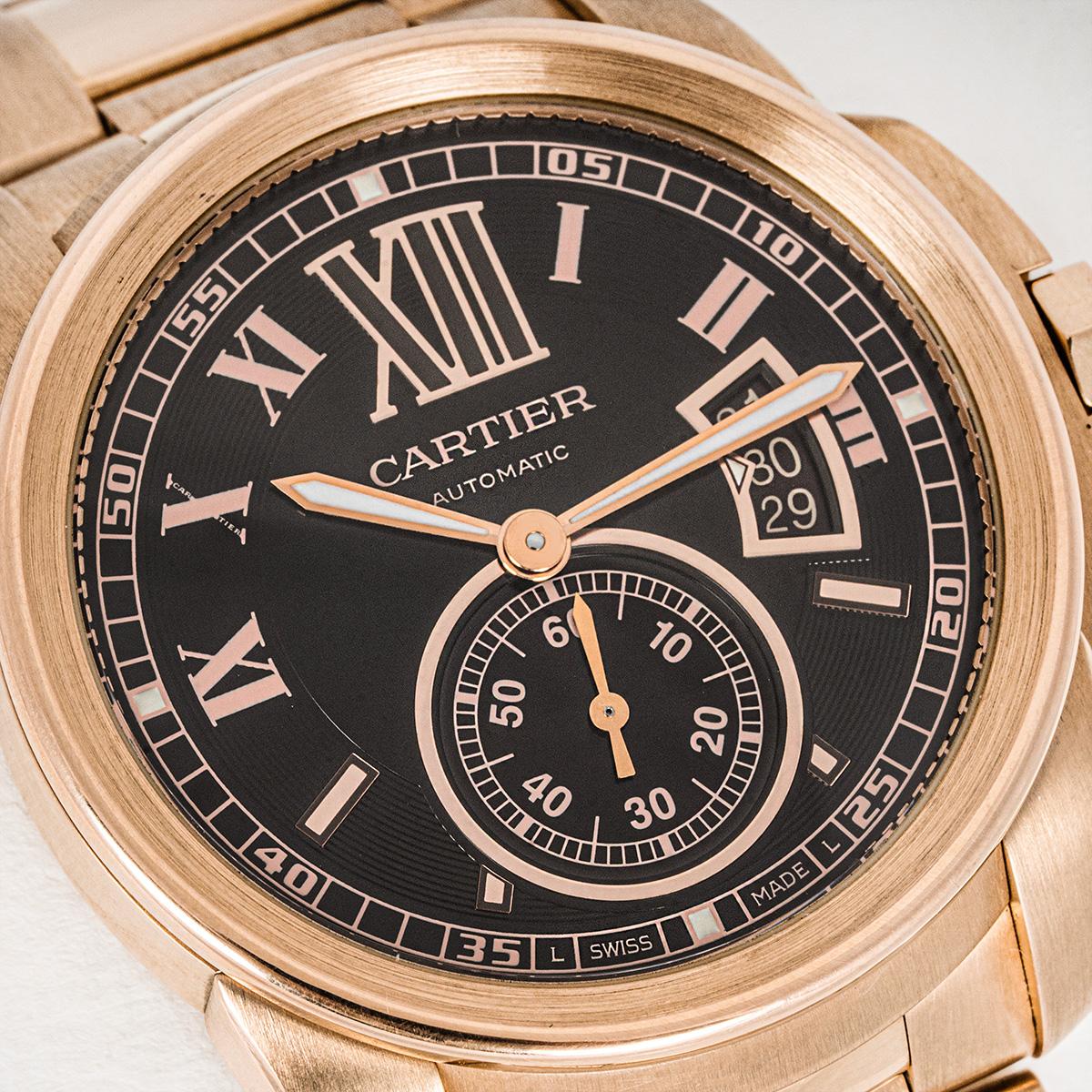 A 42mm rose gold Calibre De Cartier. Featuring a brown dial with roman numerals, a date aperture, a small seconds display, a rose gold bezel and a crown set with a faceted synthetic spinel.

Fitted with a sapphire crystal glass and a self-winding