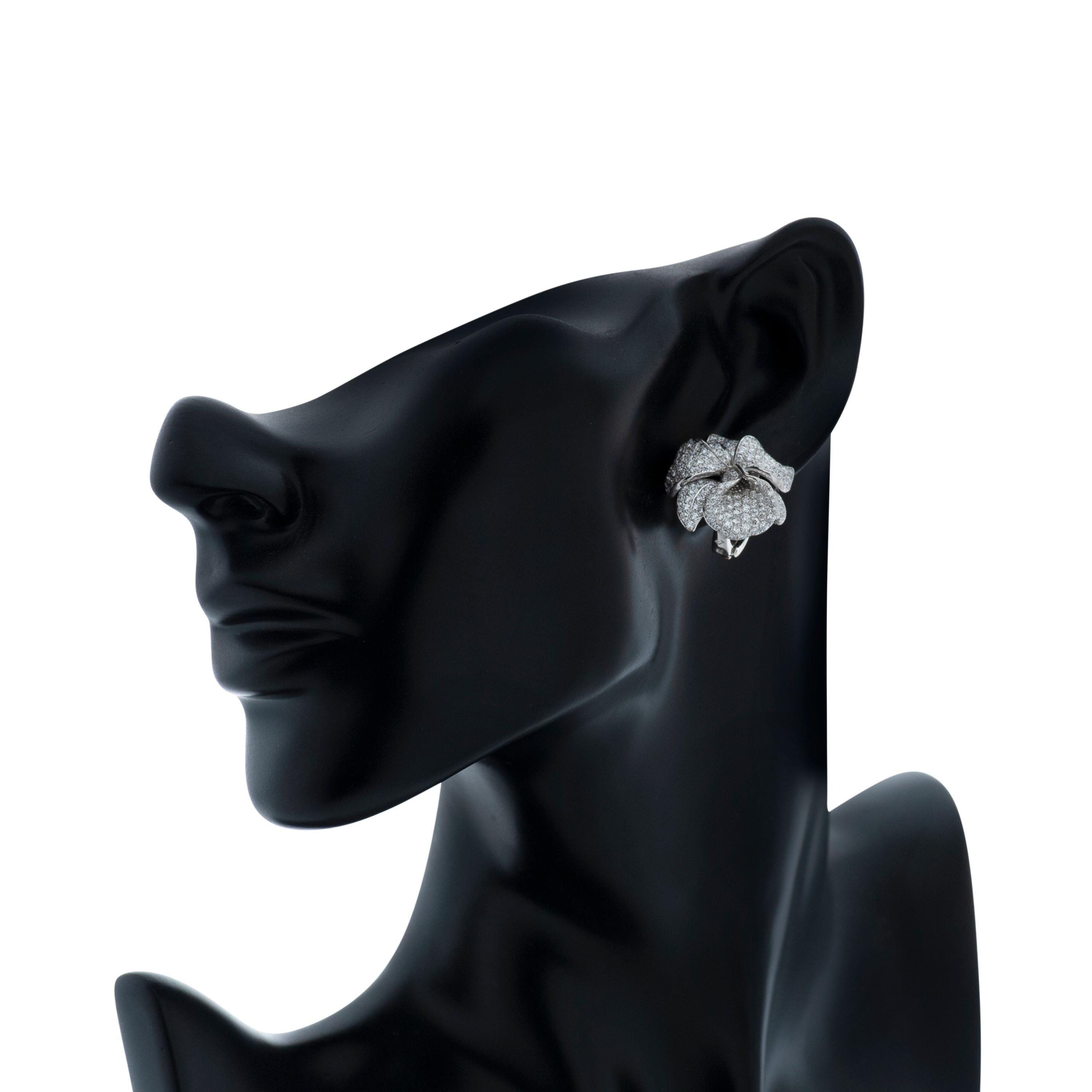Cartier Caresse D'Orchidees diamond flower earrings, accompanied by Cartier paperwork.

This pair of Cartier earrings feature 531 round brilliant cut diamonds totaling 5.53 carats pave set in platinum.

Each earring measures approximately 25mm tall