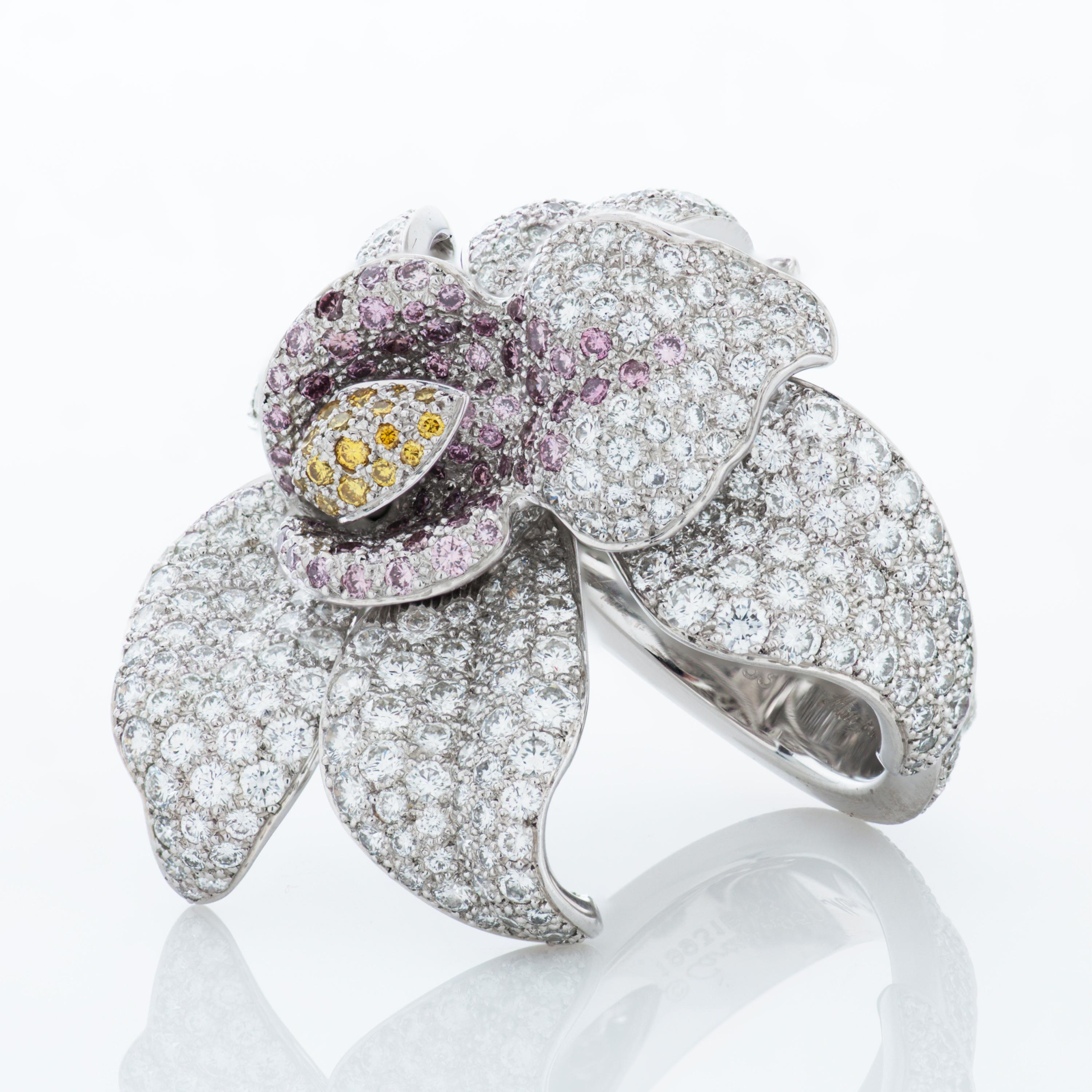 Cartier Caresse D'Orchidees pink, yellow and white diamond flower ring in platinum, accompanied by Cartier paperwork and Cartier box.  

This striking ring from Cartier's high jewelry collection features approximately 5.02 carats of pave set natural