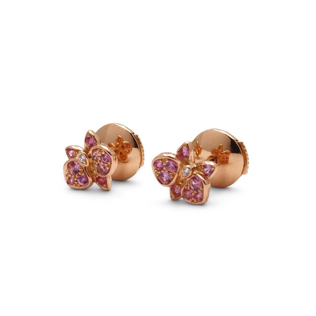 Authentic Cartier 'Caresse d'Orchidées' earrings crafted in 18 karat rose gold and features a delicate orchid-shaped motif that is embellished with pink sapphires and a center diamond. Signed Cartier, 750, with serial number and hallmarks. Earrings