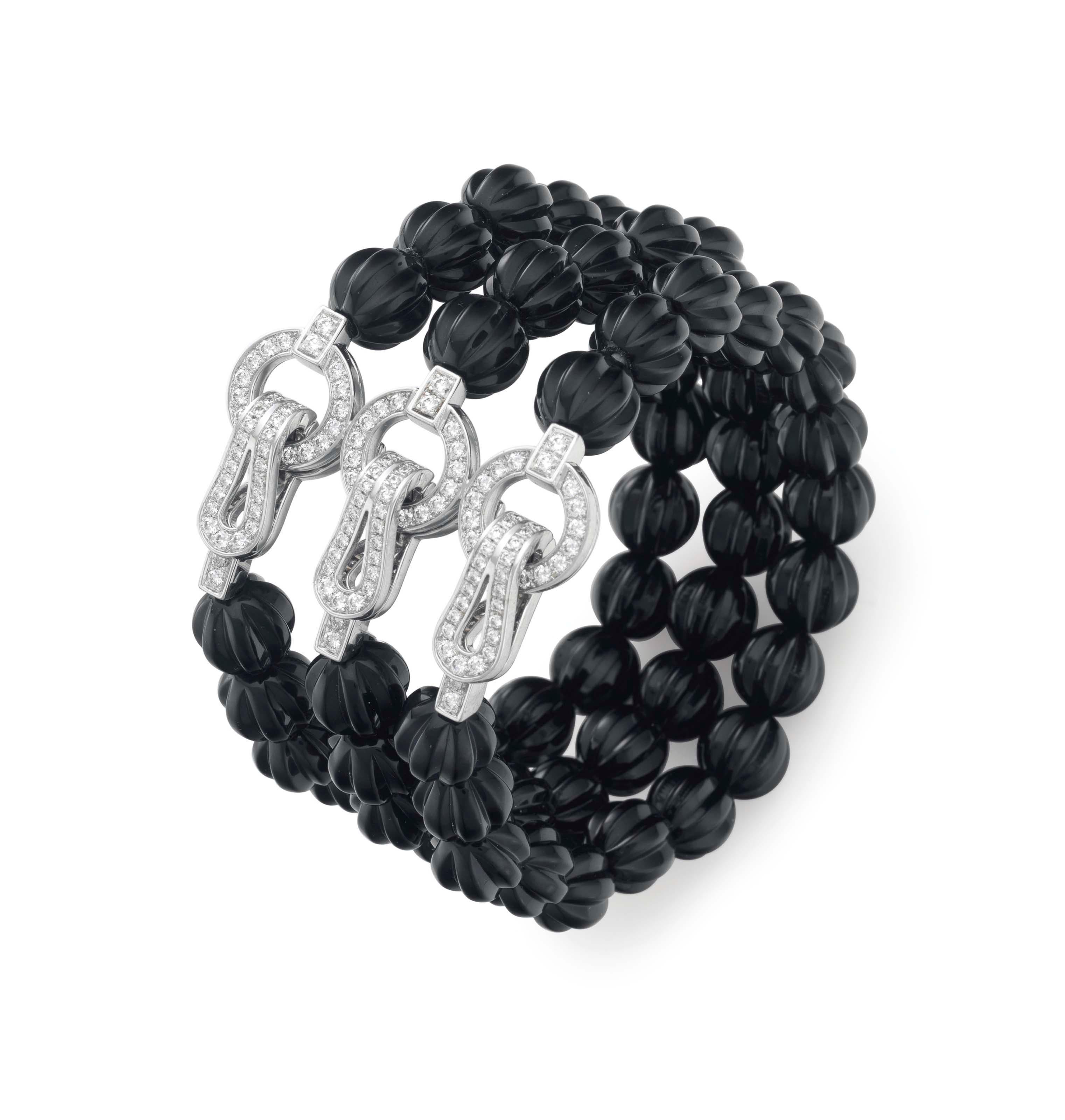 A magnificent bracelet by Cartier designed as three rows of carved onyx beads, joined by three round brilliant cut diamond stylized buckle hook clasps. The bracelet has french hallmarks, Cartier signature, and Cartier serial number.

Cartier Retail