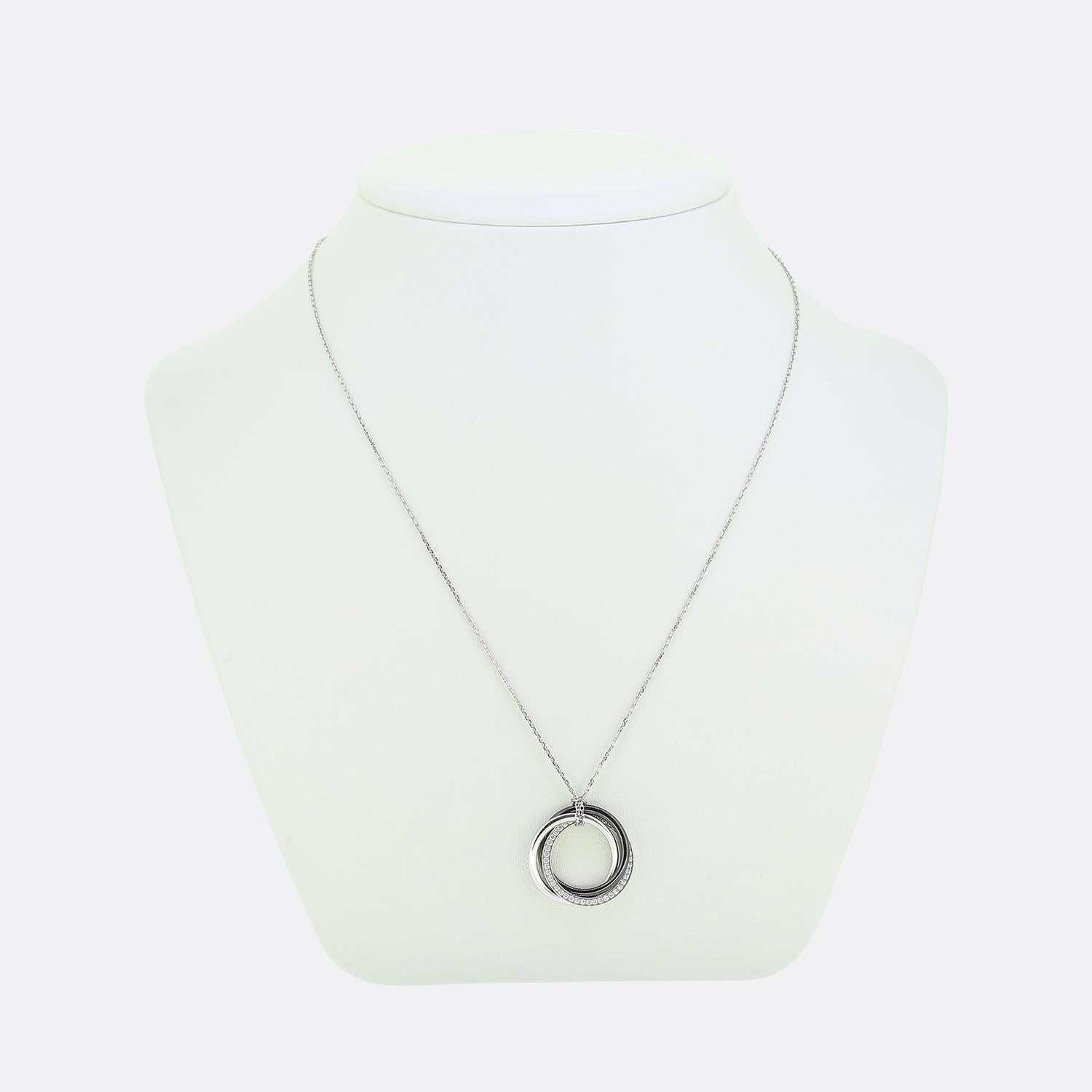 Voici un collier emblématique de la maison de joaillerie de luxe de renommée mondiale Cartier. Le design présente un trio de pendentifs circulaires imbriqués, combinant l'élégance de l'or blanc 18ct et la finesse de la céramique noire. L'un des
