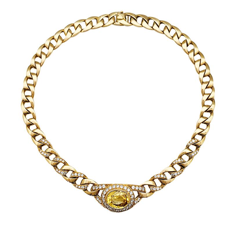 Yellow gold Cartier chaine necklace set with a 11.41 carats oval shaped yellow sapphire surrounded with brillant-cut diamonds for a total weight of 3.17 carats, the chain is also partially set with brilliants on six links each side of the