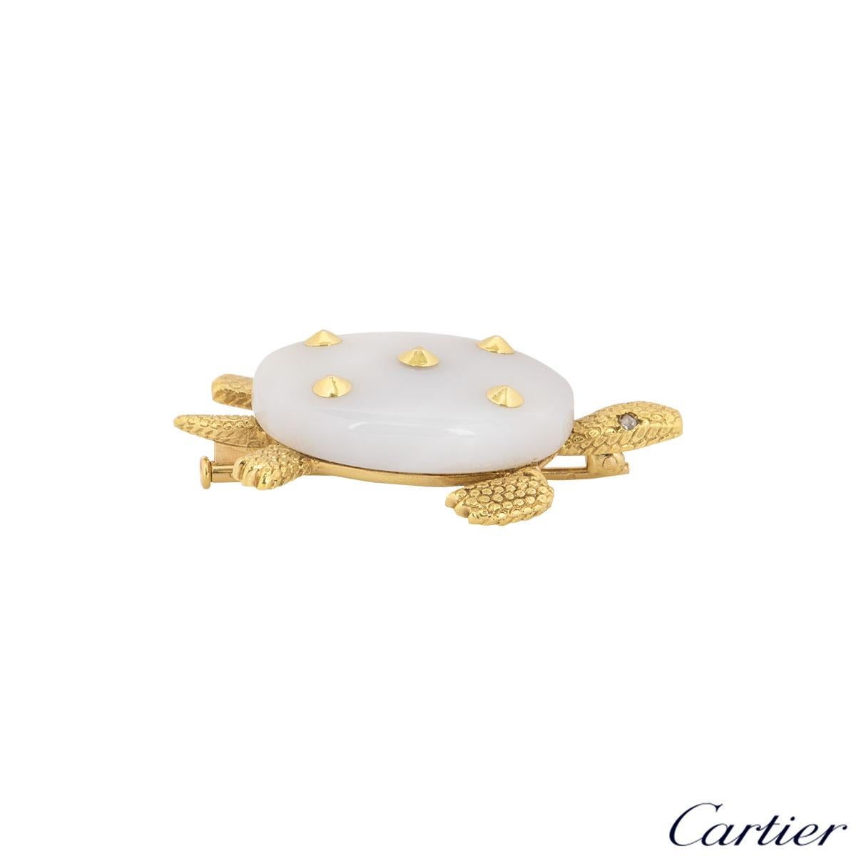 An 18k yellow gold chalcedony brooch by Cartier. The brooch is set in a design of a turtle with a chalcedony shell accompanied by 5 yellow gold studs and textured yellow gold body with 2 rose cut diamonds for eyes with an approximate total weight of