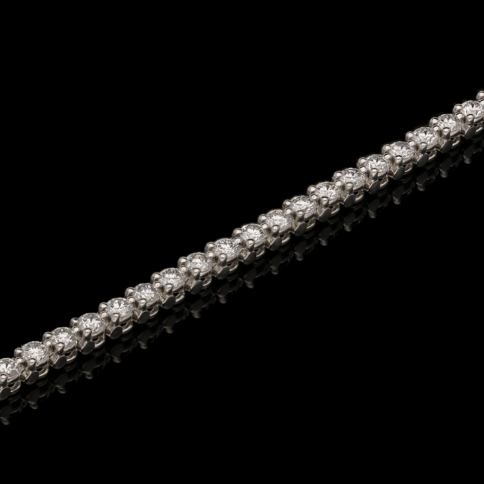 A beautiful diamond line bracelet by Cartier circa 1960s, the single row of round brilliant cut diamonds in platinum open claw settings in a highly articulated mount with concealed tongue and box clasp with additional safety catch. This is a classic