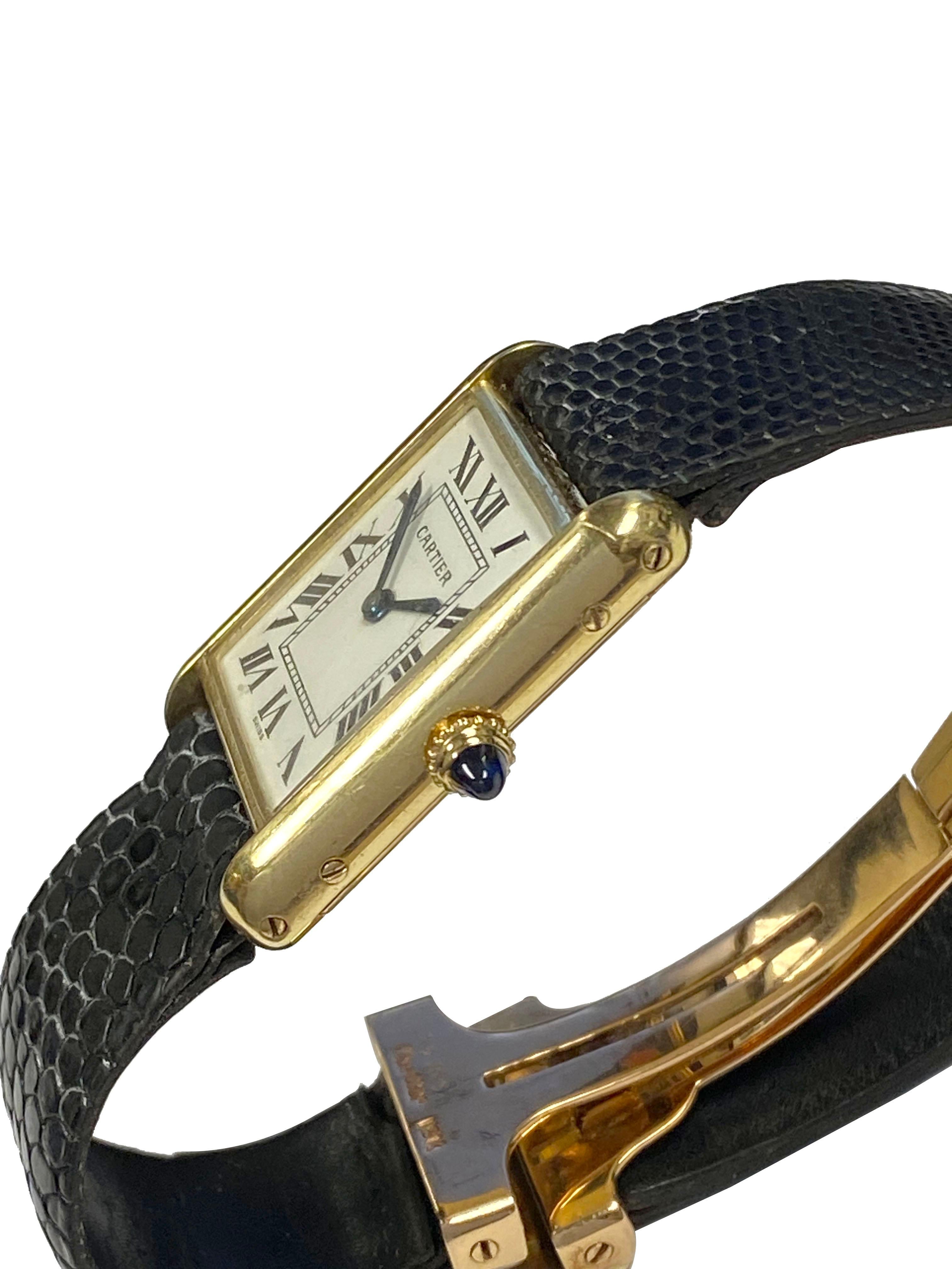 Circa 1970 Cartier Classic Tank Wrist Watch, 22 X 23 M.M. ( standard Size ) 18k Yellow Gold 2 piece case, mechanical, manual wind movement, sapphire crown, White Dial with Black Roman numerals. Black Cartier Lizard Strap with original Cartier 18k