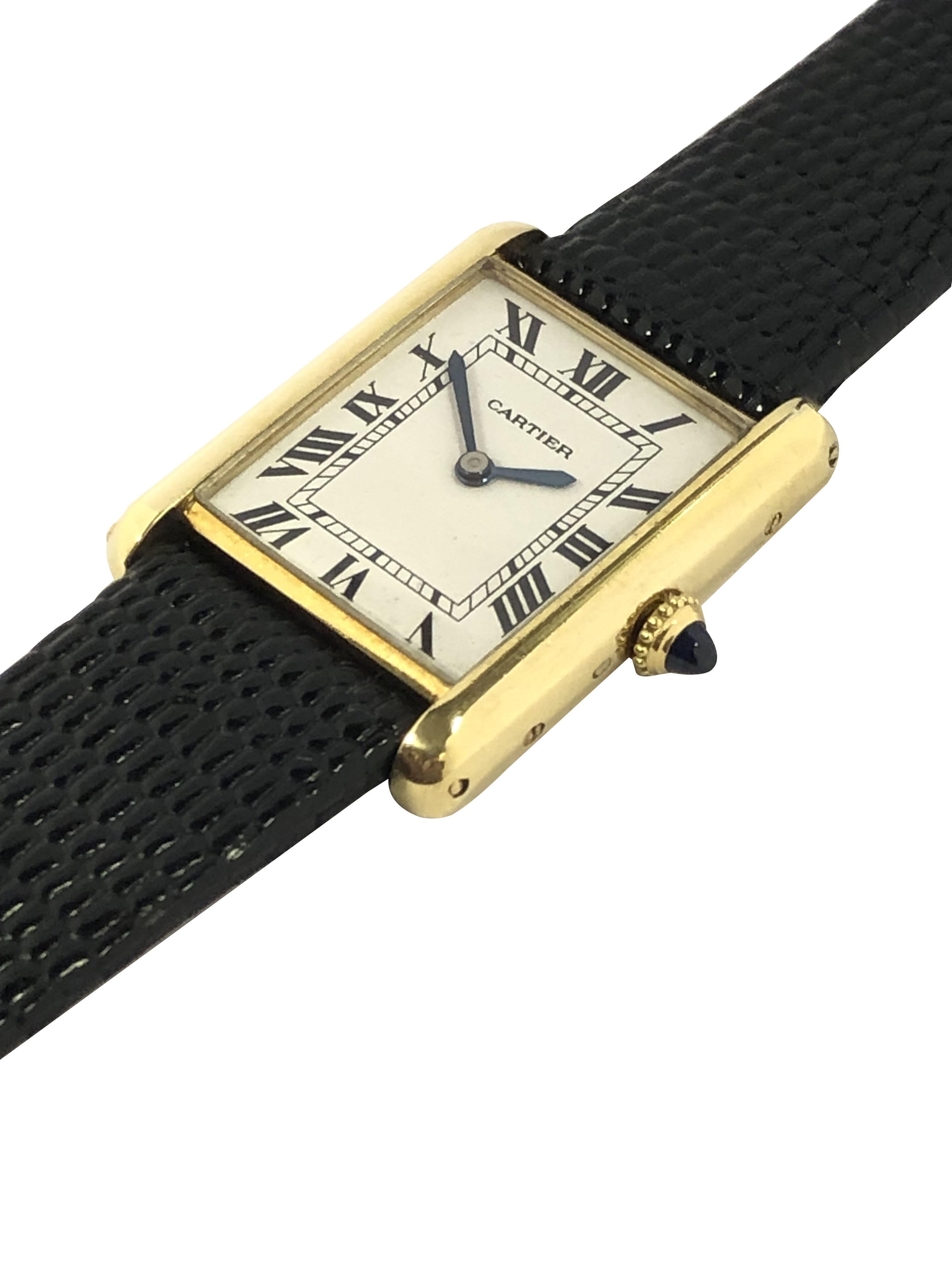 Circa 1980s Cartier Tank collection Wrist Watch, 23 X 22 M.M. 18k Yellow Gold 2 Piece case, 17 Jewel Cartier Inc. mechanical, manual wind movement, Sapphire Crown, White dial with Black Roman Numerals. New Black Lizard Grain Strap. Comes in a