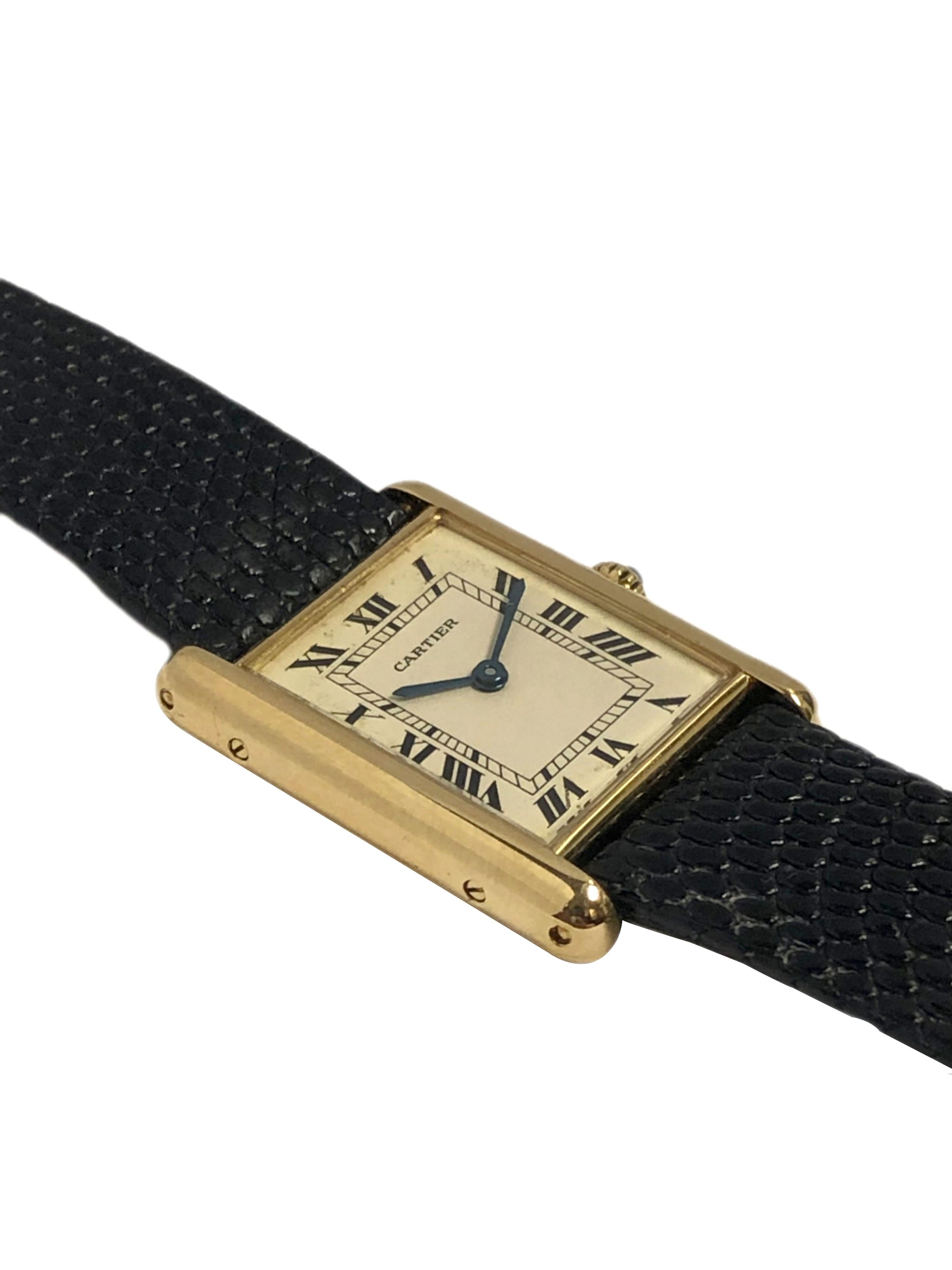 Circa 1990 Cartier Classic Tank mid size Wrist Watch, 30 X 23 M.M. 18K Yellow Gold 2 Piece case, quartz movement, silvered dial with Black Roman numerals, Sapphire Crown. New Black Lizard strap with Gold Plate Cartier Tang Buckle. Watch length 8 1/4