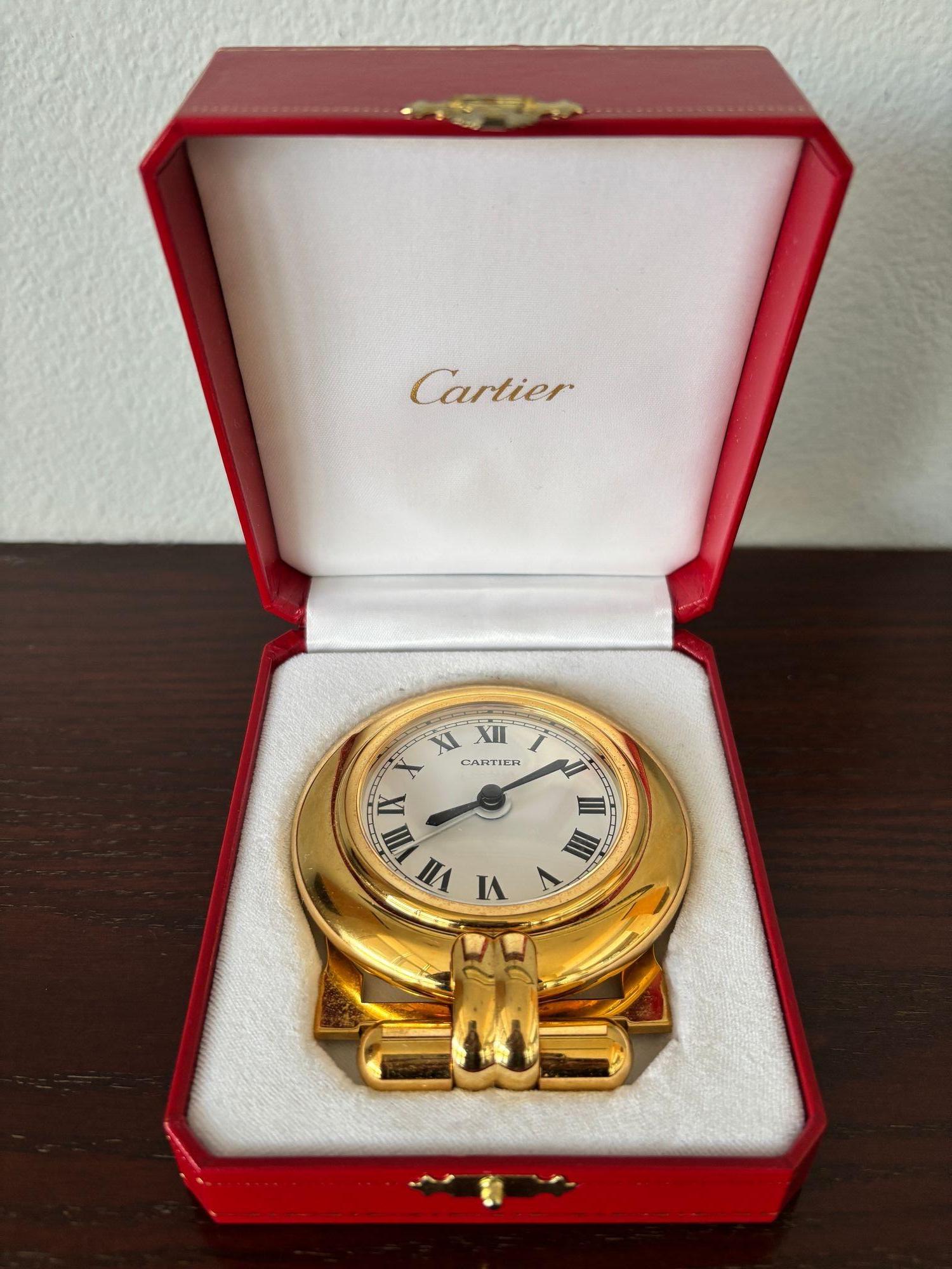 Vintage Cartier 24-karat gold-plated Art Deco travel quartz desk clock with alarm.
Cartier Paris 24-karat gold-plated and lapis lazuli quartz travel or desk accessory clock is no longer being made.
It is vintage from the 1990s. It was originally