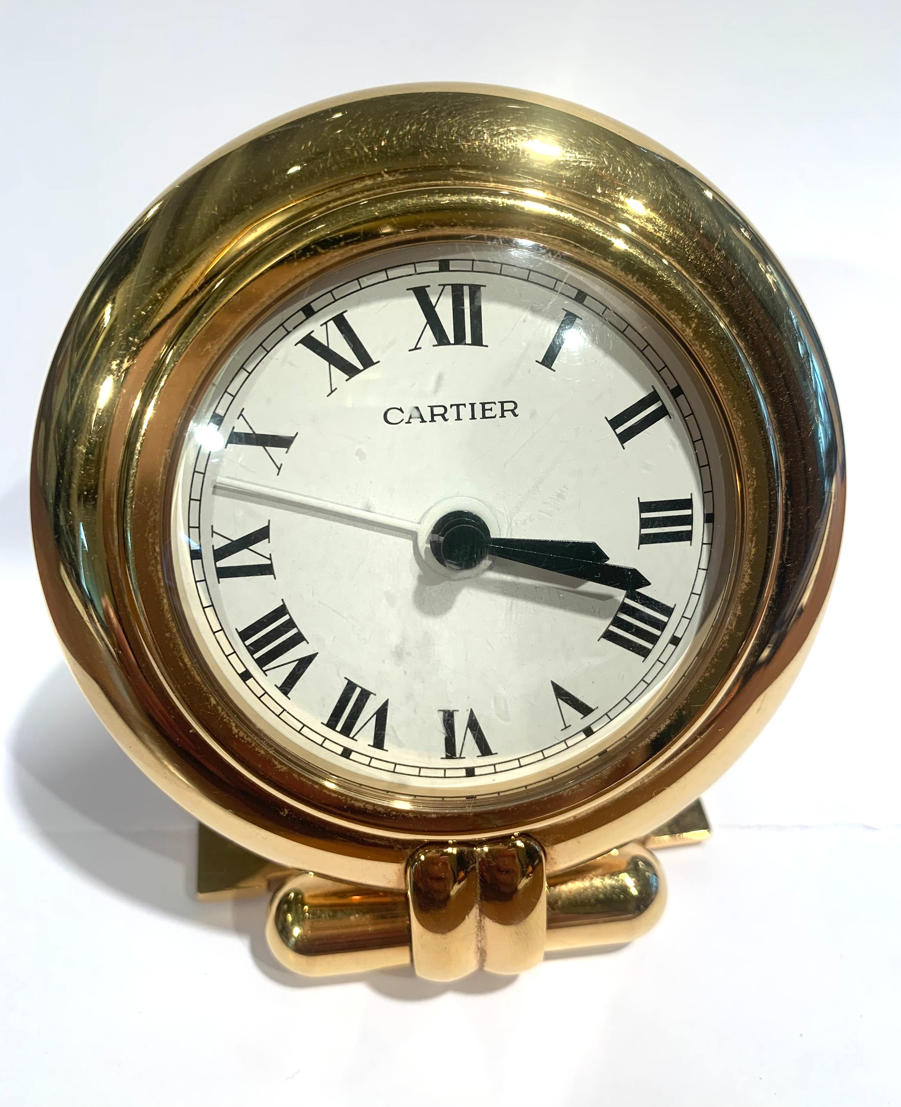 Very nice Cartier clock with a round case resting on an easel formed by the C of Cartier. White dial with Roman numerals, railroad timer and white hand to adjust the alarm function.

Model: Colisée

Year: 1998

Case: Gold plated stainless