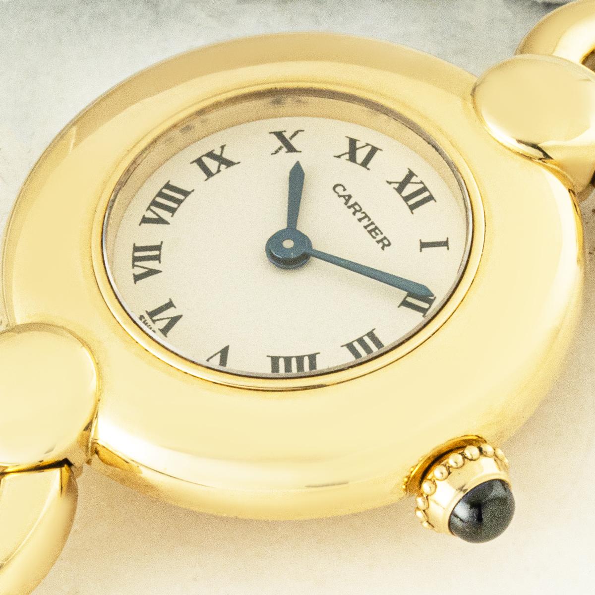Une montre vintage pour femme de Cartier, de la collection Colisée, référence 1989 1. Cet élégant garde-temps présente le boîtier rond caractéristique de Cartier, associé à un exquis bracelet à maillons circulaires en or jaune 18 carats mesurant