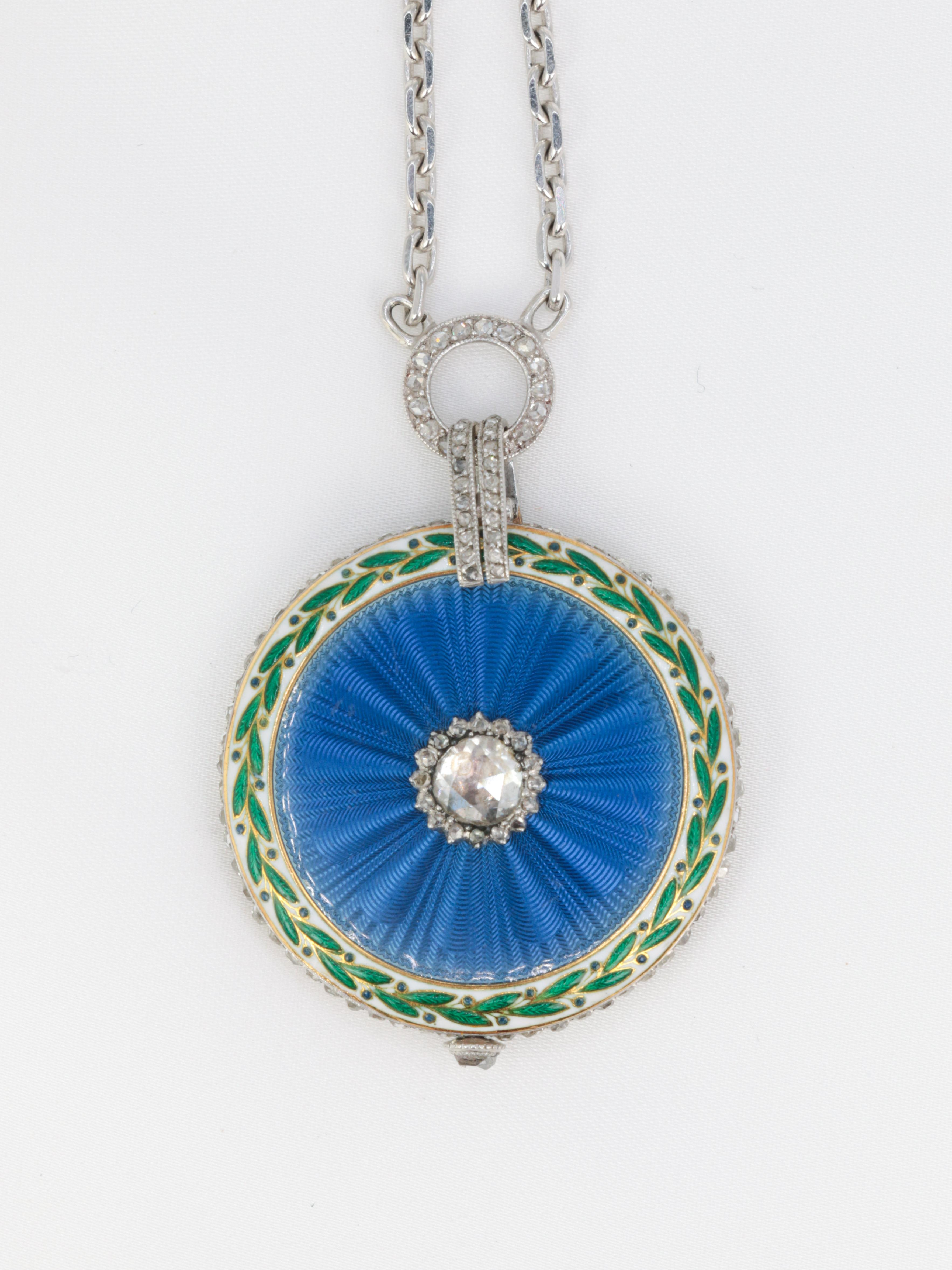CARTIER 
18Kt (750°/°°) gold Collar watch/Pendant in 18k set with diamonds and enamel. The back of the watch is decorated with blue guilloché enamel and circled with white and green enamel figuring a floral motif. In the center, the watch is set