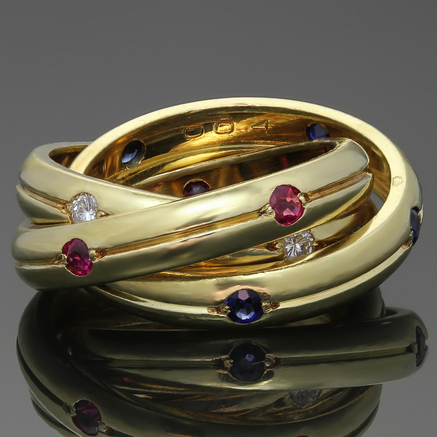 Dieser klassische Ring aus der ikonischen Kollektion Constellation Trinity von Cartier besteht aus drei ineinander verschlungenen 4,0-mm-Bändern aus 18-karätigem Gelbgold, die mit runden Diamanten im Brillantschliff, roten Rubinen und blauen