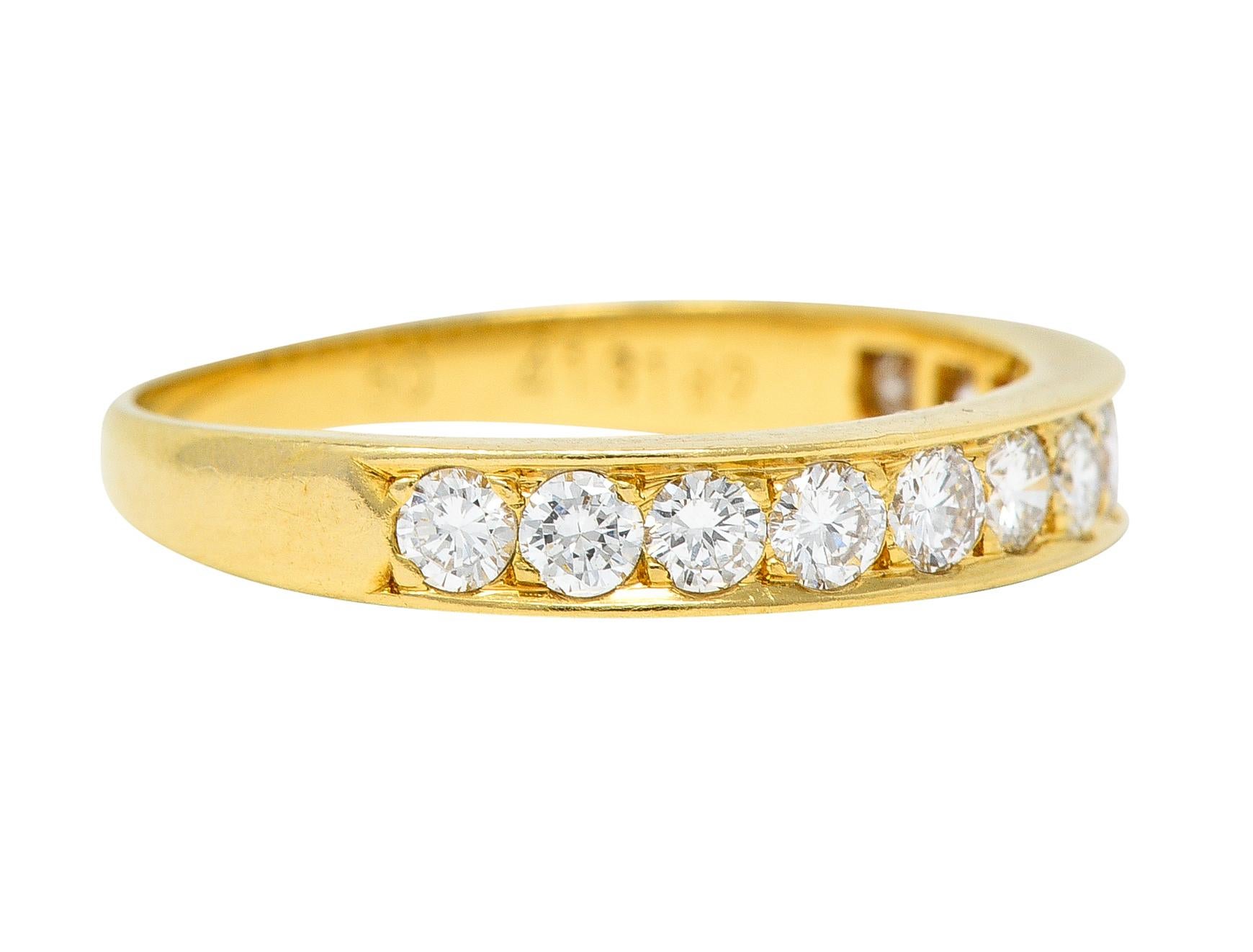Featuring round brilliant cut diamonds bead set to front in a recessed channel. Weighing approximately 0.48 carats total - G/H color with VS clarity. Band tapers and has a high polish finish. Stamped 750 for 18 karat gold. Numbered and fully signed
