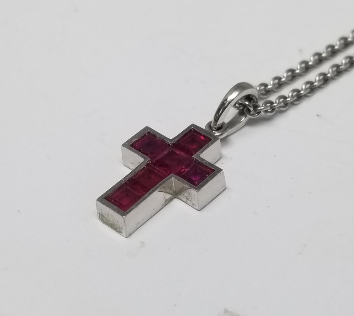 A beautiful Estate cross necklace by legendary maker Cartier! The lovely piece is made of platinum and forms the shape of a delicate cross. The entire front surface of the cross is represented by 6 calibrated rubies, totaling approximately .90ctw.